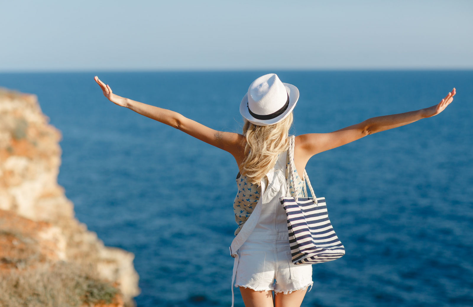 woman with arms wide open on the beach