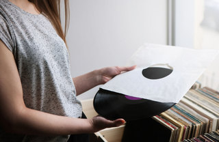 Woman taking a vinyl record out of its sleeve