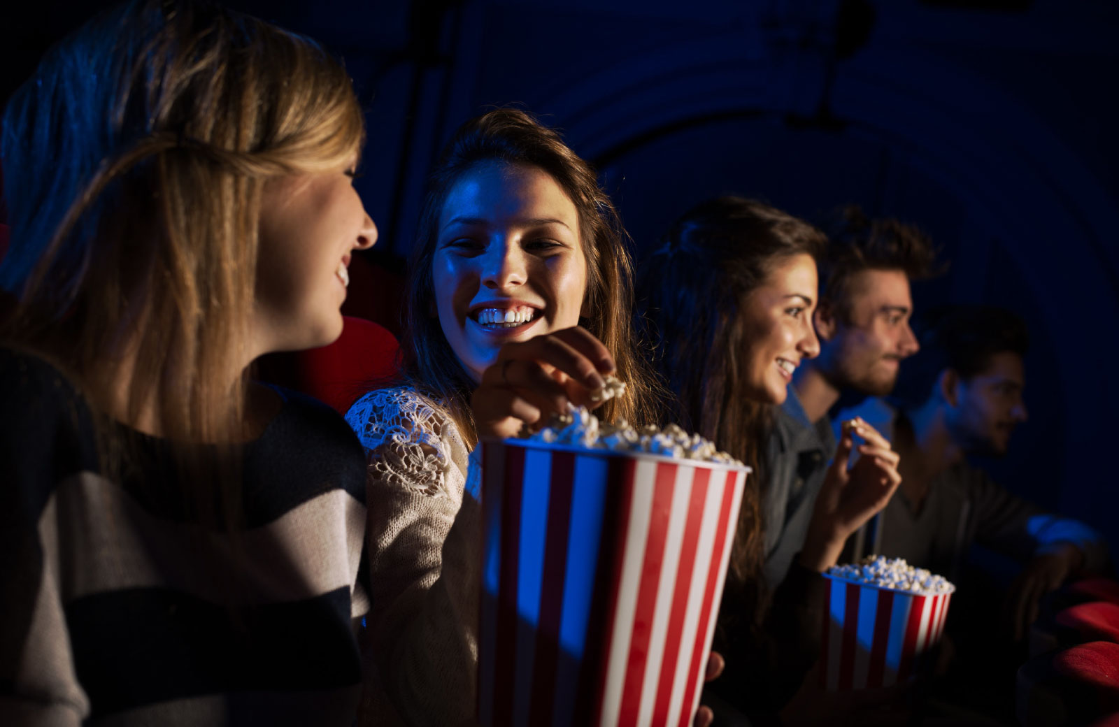 group of people watching movie in a cinema eating popcorn
