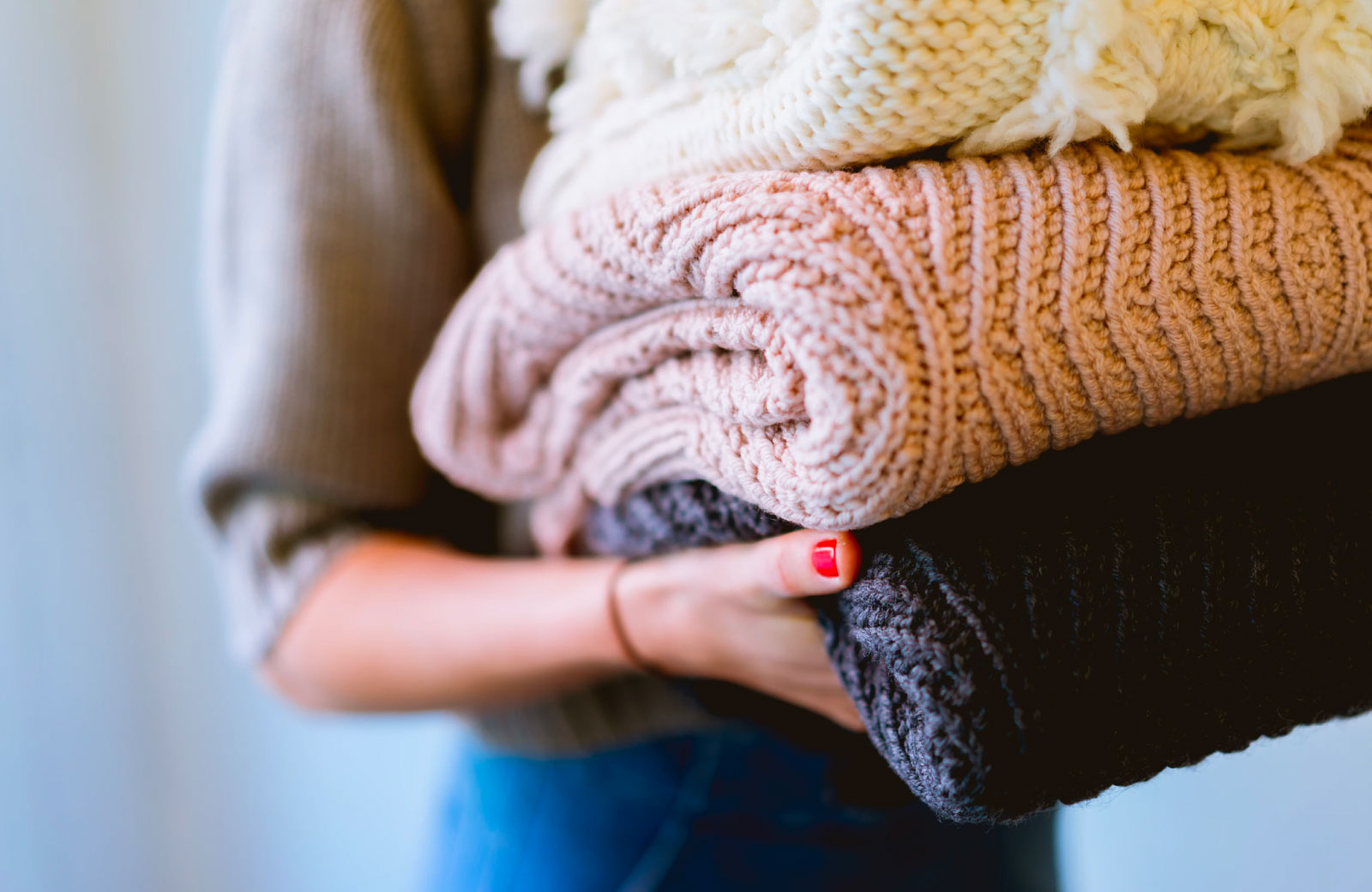 woman carrying knitted blankets