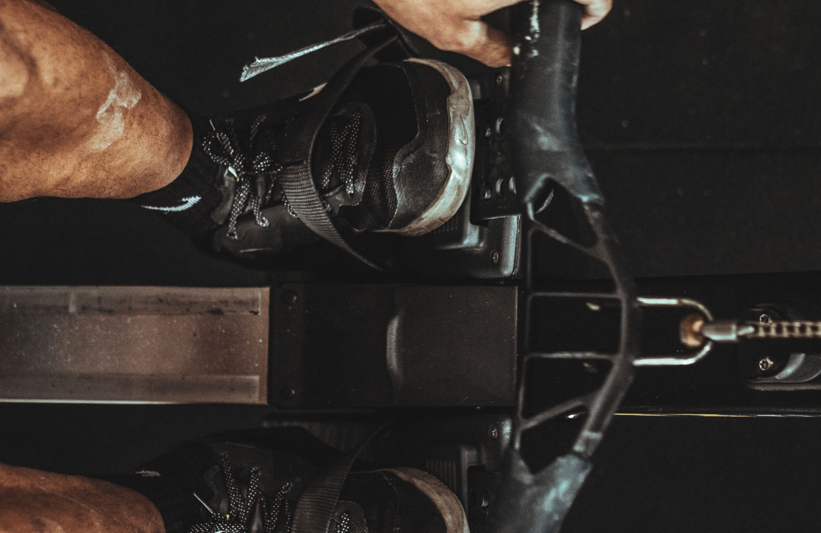 person with black shoes working out in a gym machine