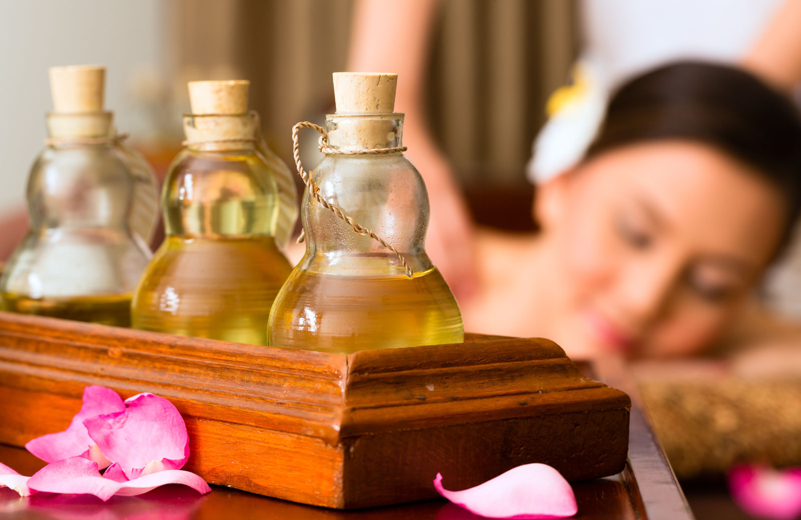 woman relaxing with a bottle of oil in the foreground