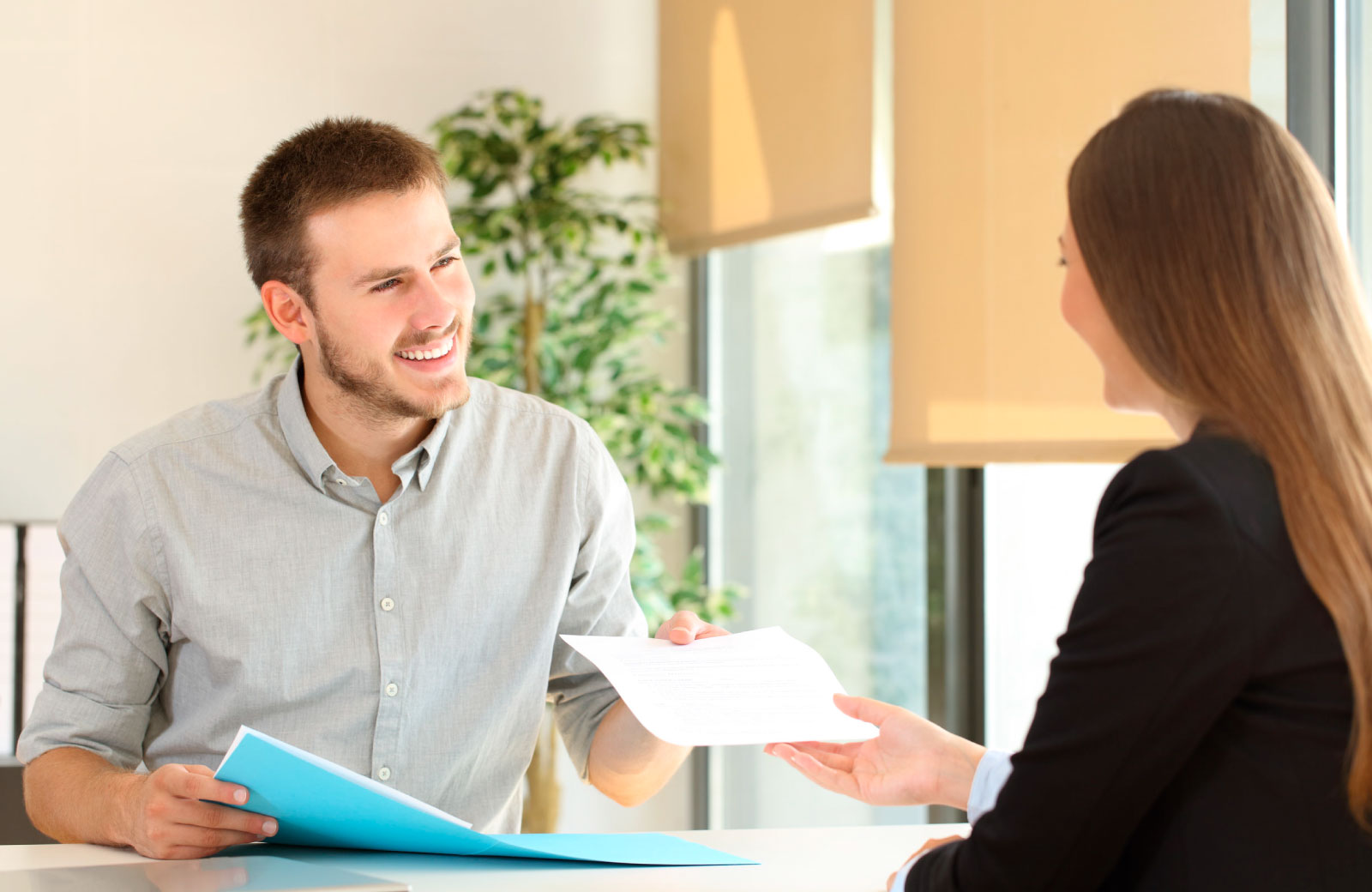 man handing a piece of paper to his colleague