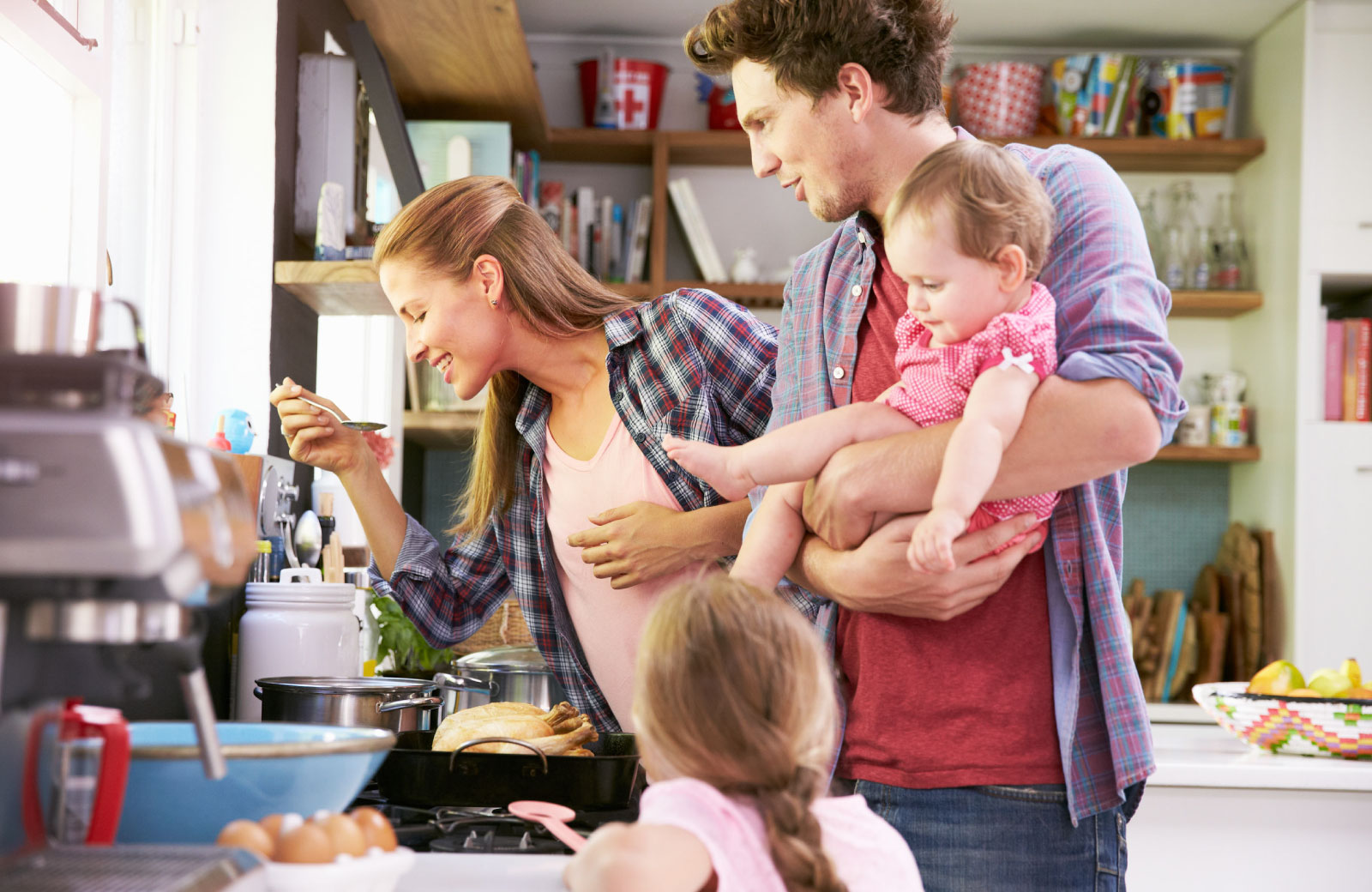 mom tasting her dish with dad and kids looking on