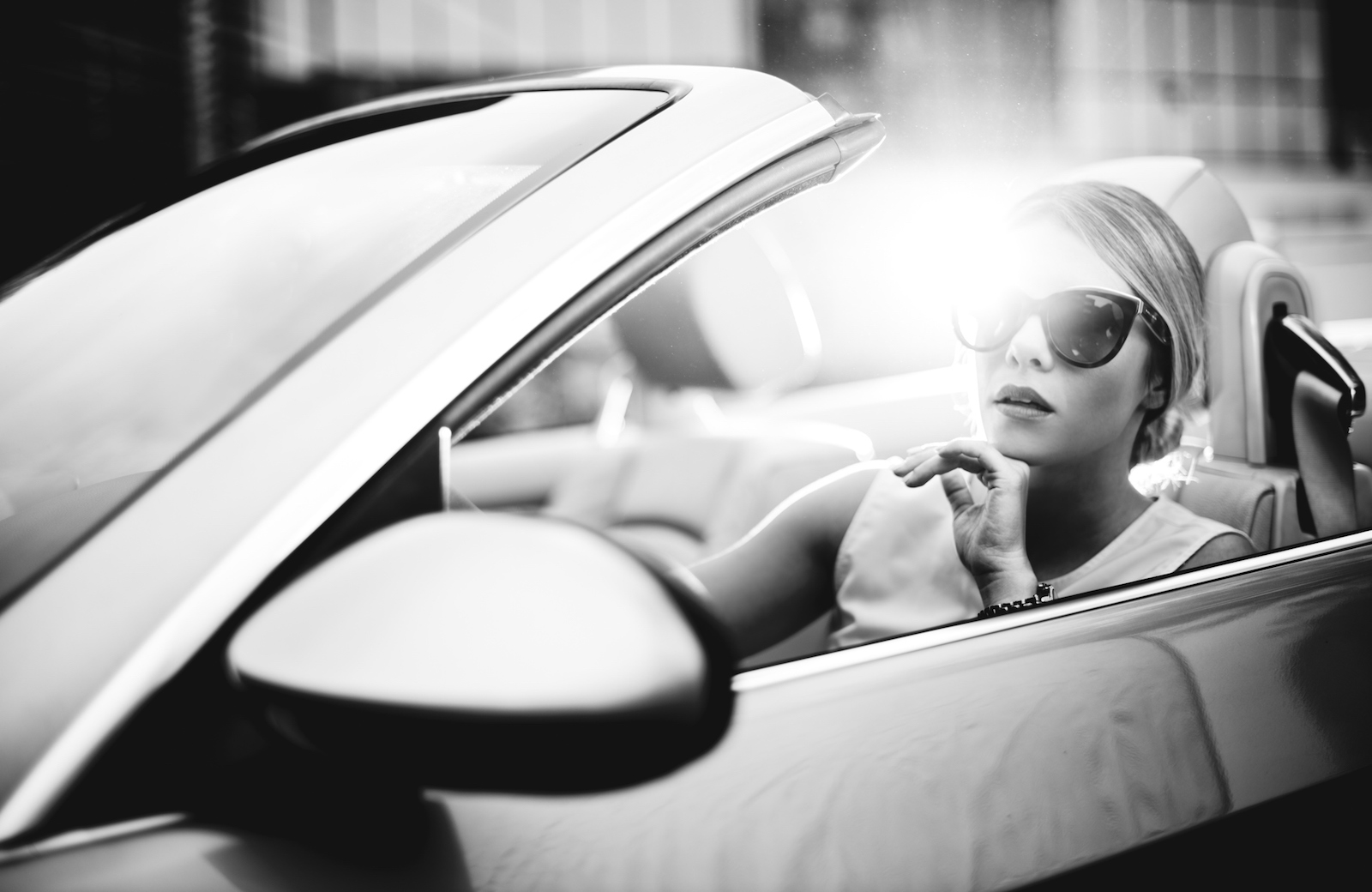 Black and white photo of a woman driving her convertible