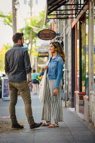 A man and woman on the sidewalk outside Paxti's storefront