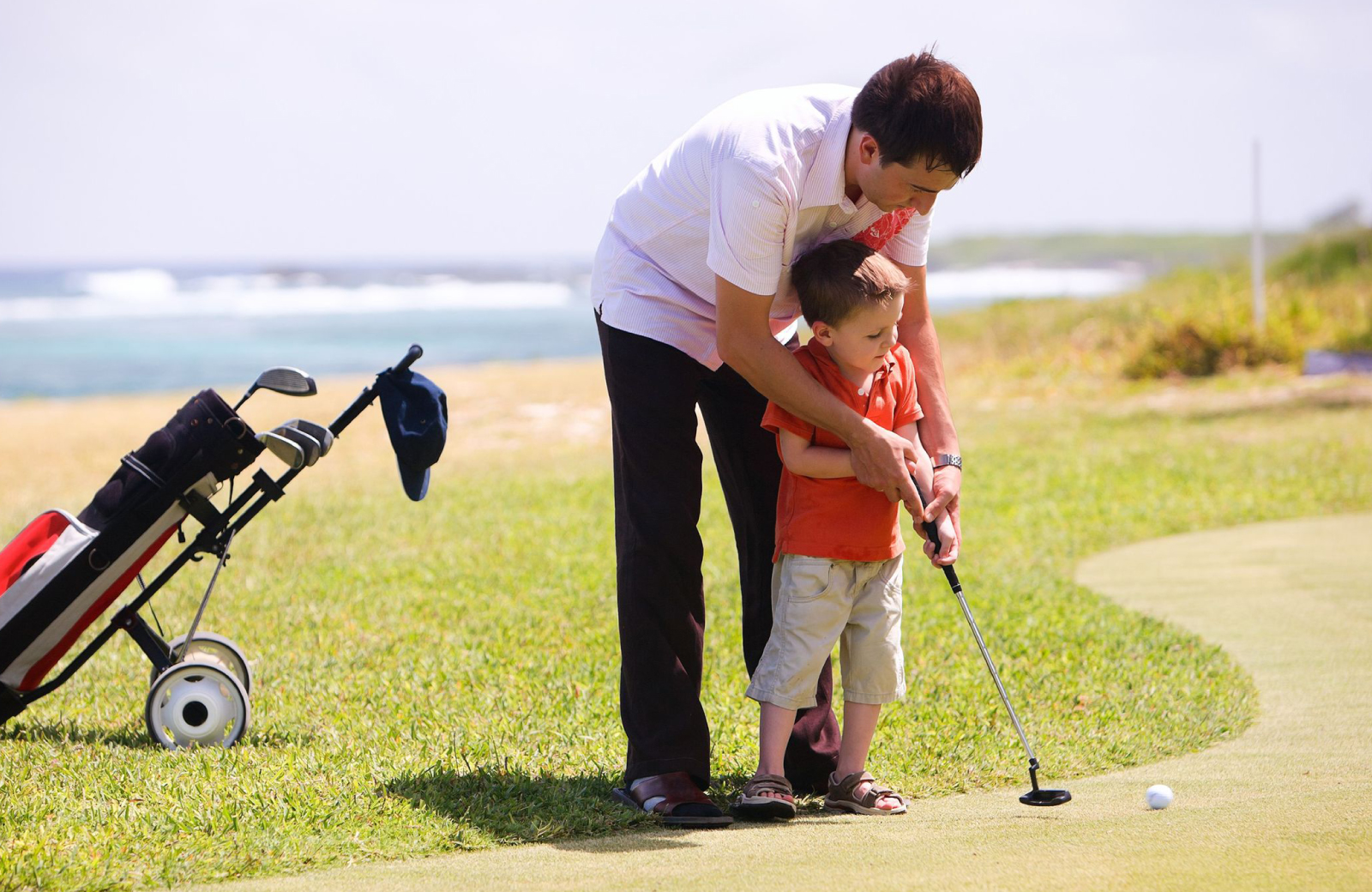 Father And Son Playing Golf - Altana Apts