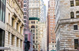 Colorful, beautifully lit buildings at dusk in the Financial District of Lower Manhattan.