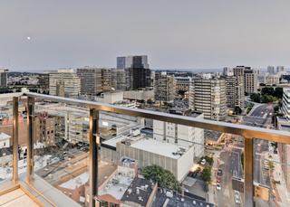 Downtown Stamford skyline view from a high-rise terrace with city streets, office towers, and the Long Island Sound in the distance