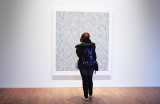 A woman looking at a painting in a museum