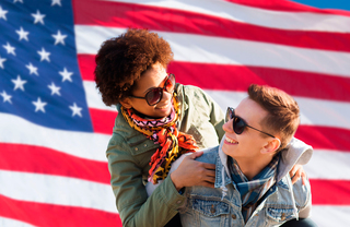 A young couple in front of a United States flag