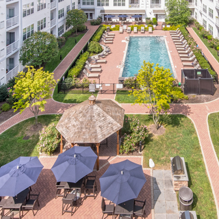 Downward view of apartment courtyard, with pool and dining area