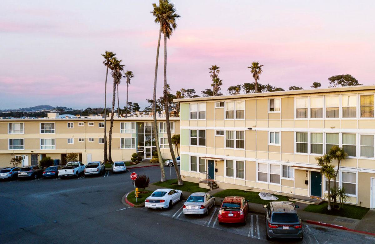 South Palm apartments  mid-century style with flat roofs, picture windows, palm trees, and resident street parking.