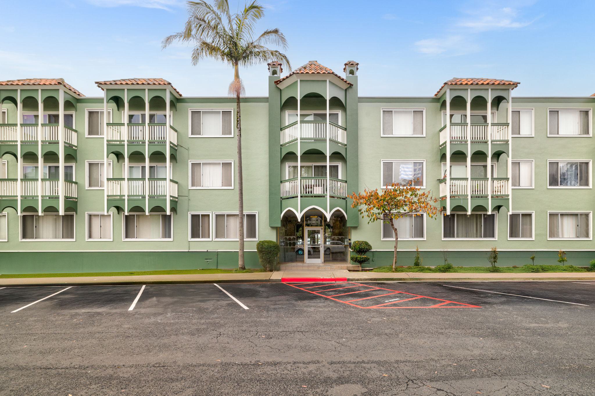 Multi-level Juniper apartment building with stucco exterior, tiled roofs, balconies, and  large picture windows