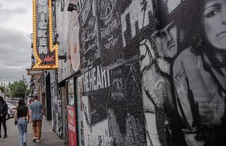 People walking in front of a graffiti wall
