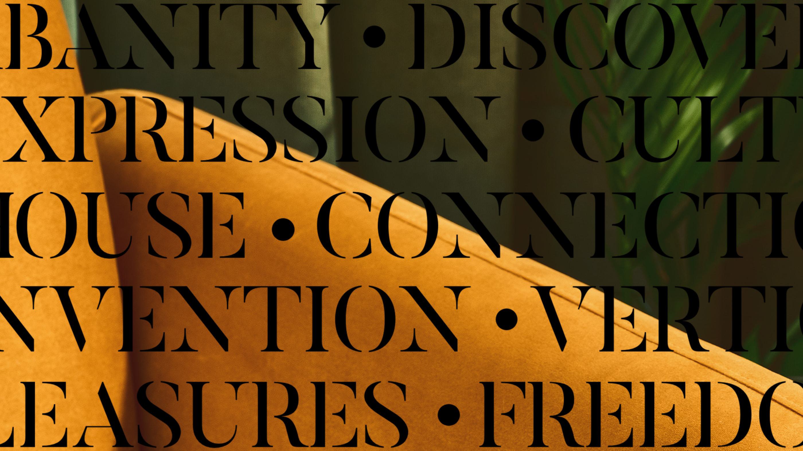Close-up of mustard yellow upholstered seating with bold black typography overlaid, featuring words like “EXPRESSION,” “CONNECTION,” and “FREEDOM,” set against a moody interior with hints of greenery in the background.