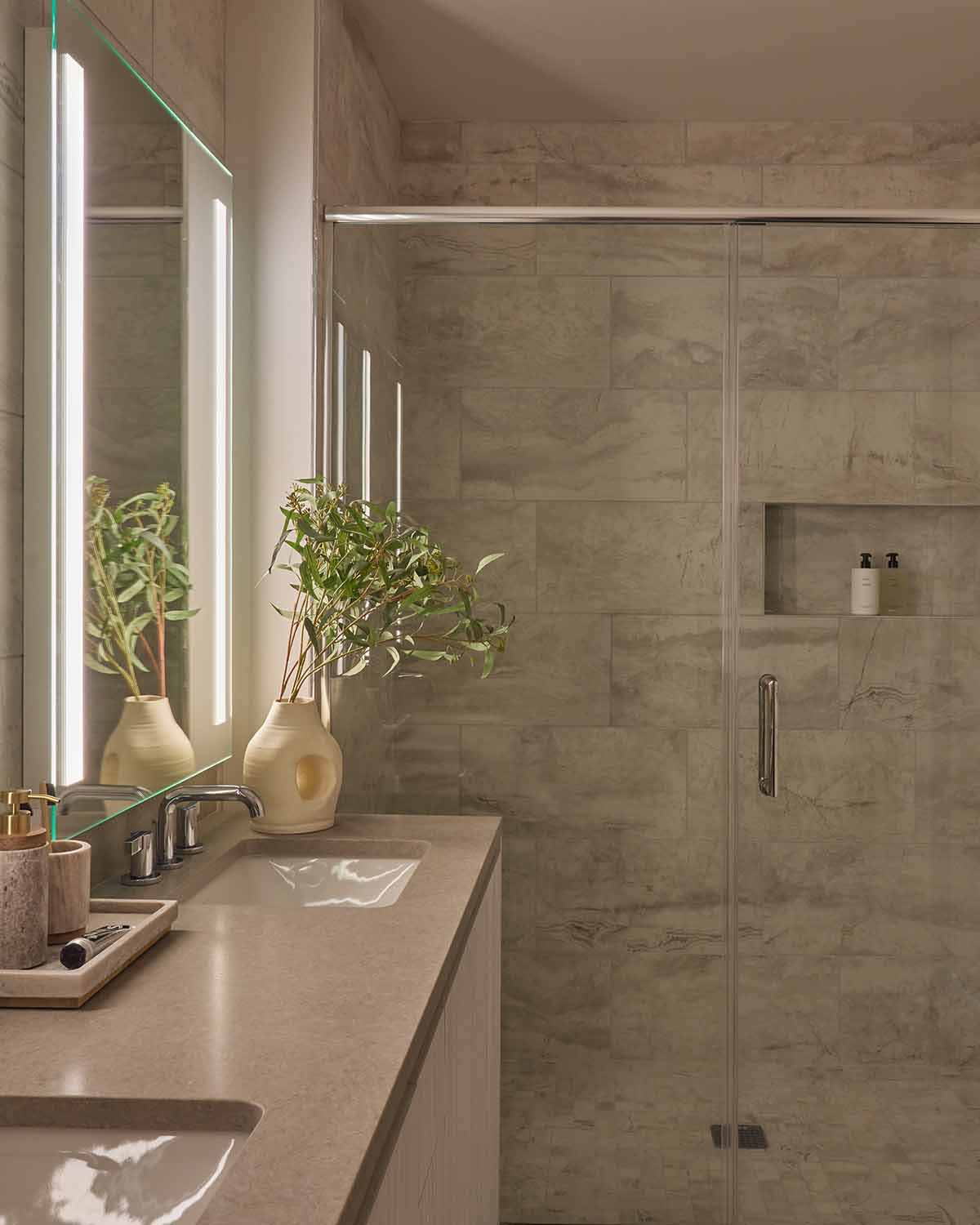Bright, modern living space in an upper-floor Alloy Collection residence, featuring floor-to-ceiling windows, sleek kitchen finishes, and curated furnishings.