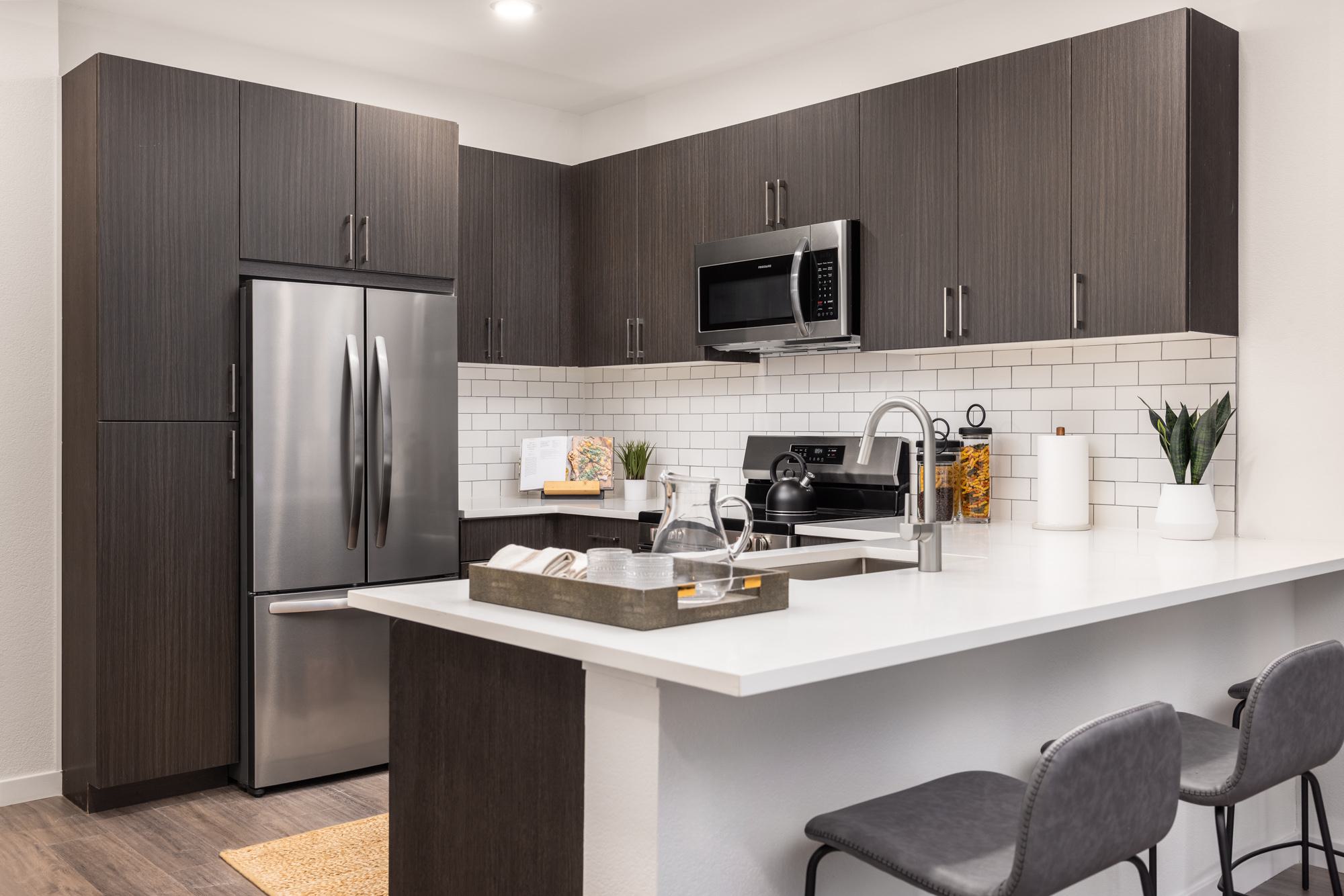 Kitchen with dark brown cabinetry and subway tile backsplash