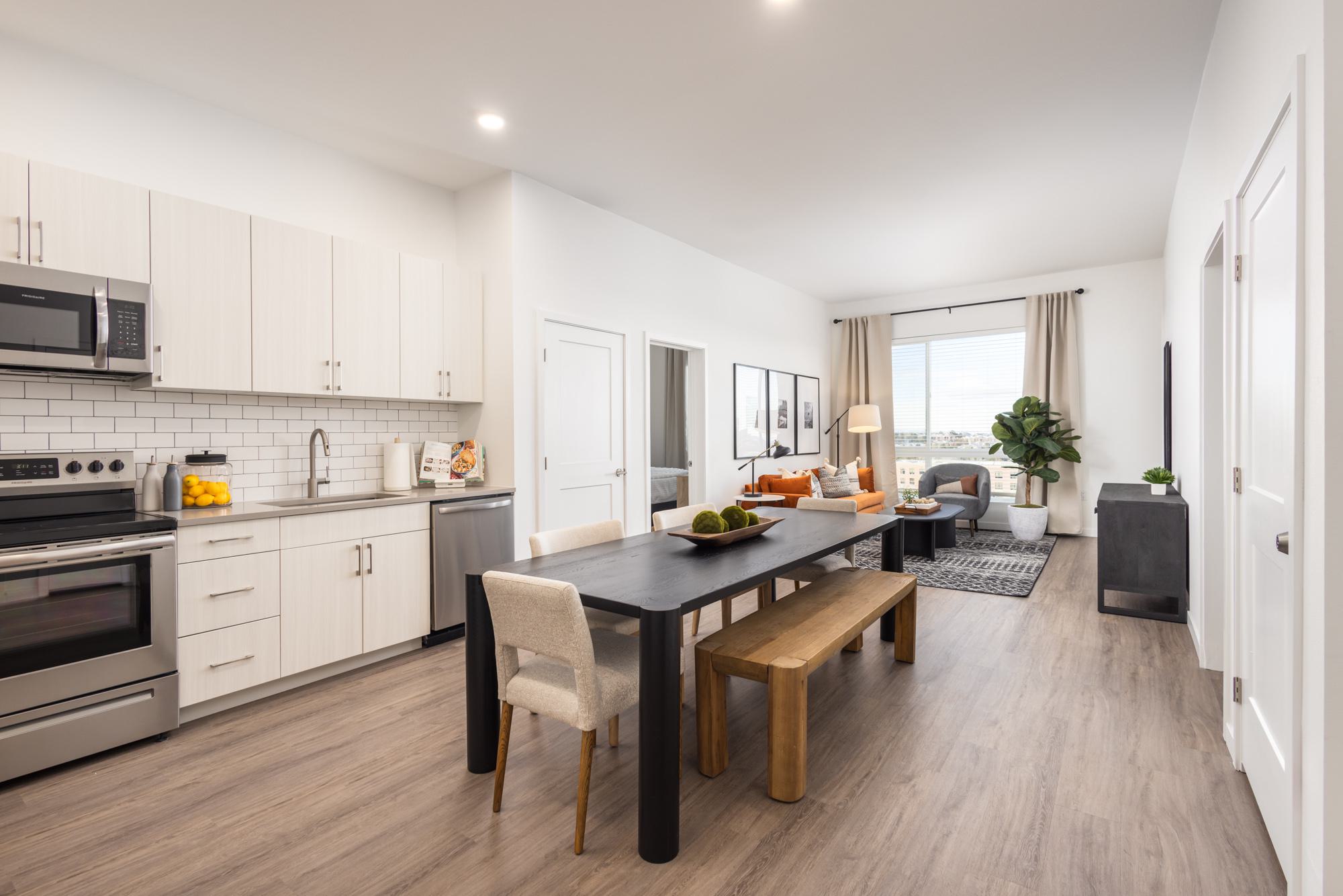 Kitchen with light cabinetry, wood-style flooring and view to living room