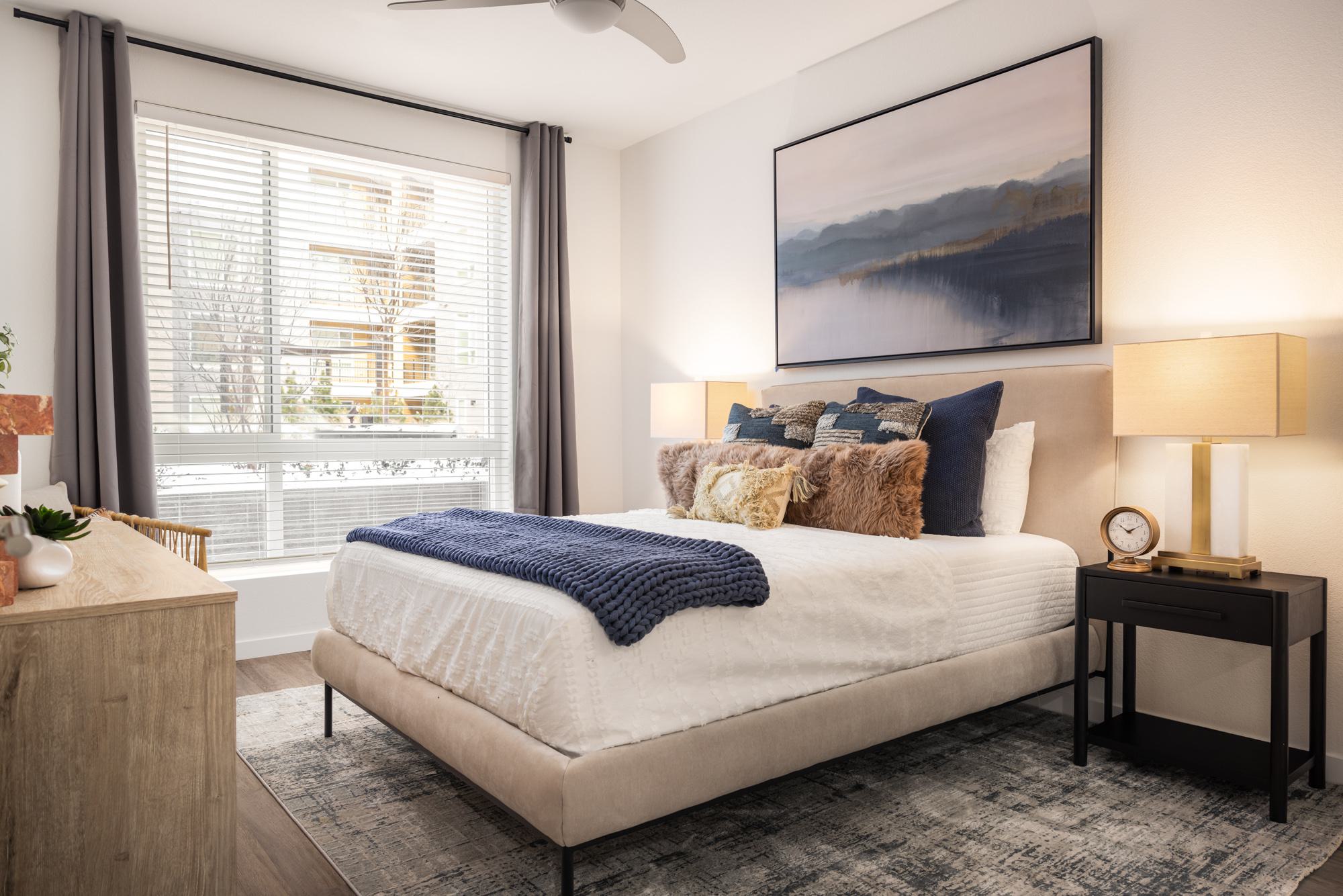 Bedroom with large window, ceiling fan and wood-style flooring