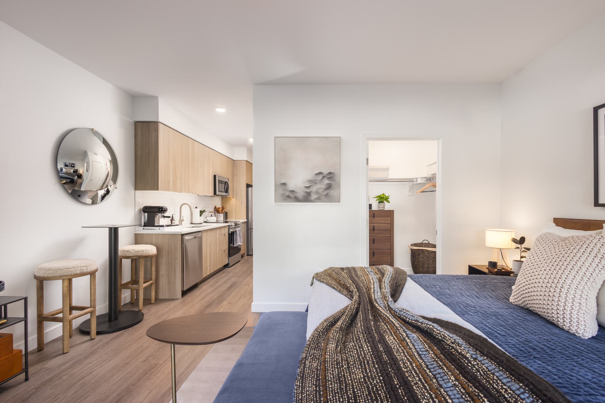 Studio apartment with a full kitchen, cozy sleeping area, and walk-in closet.