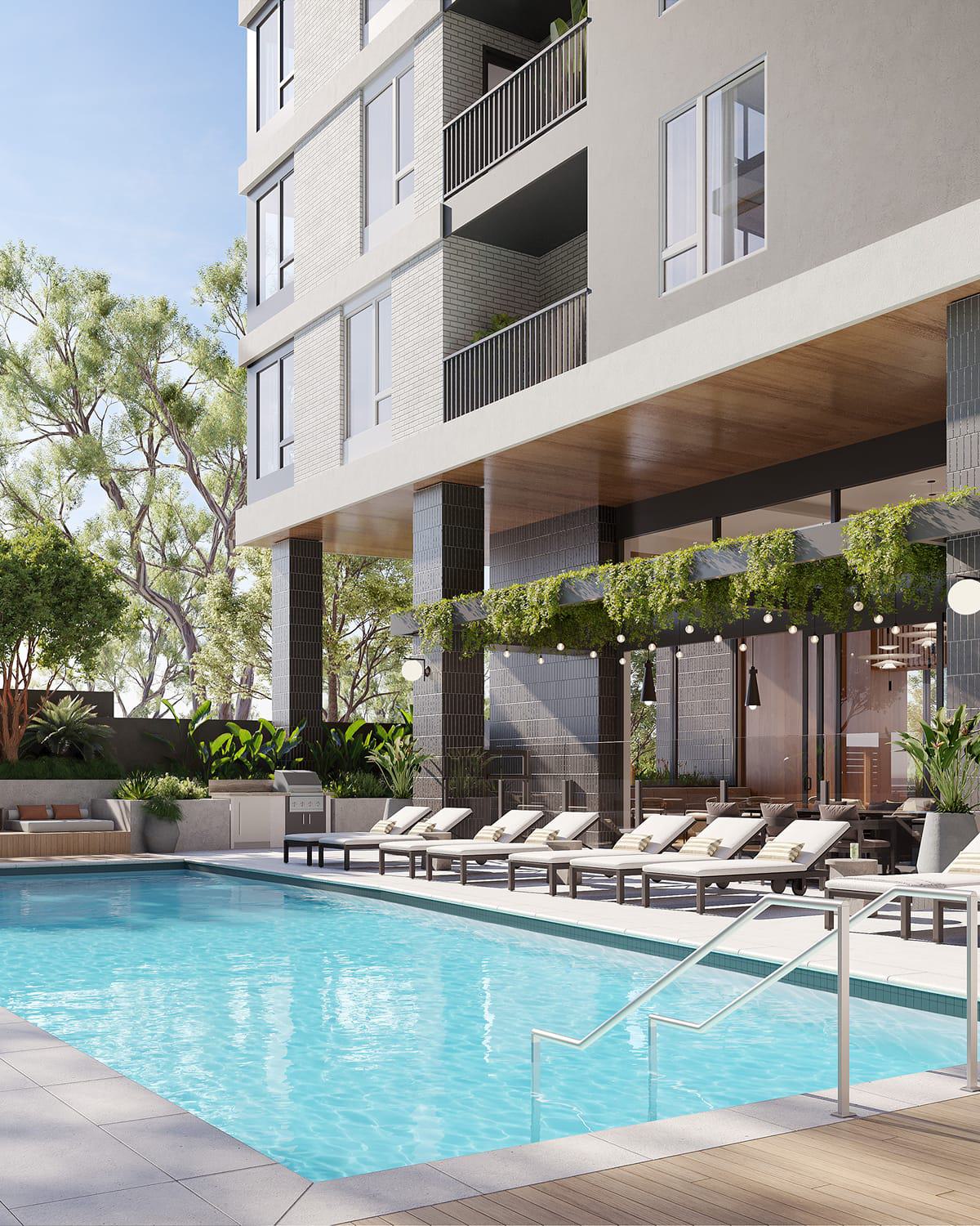 A sunlit outdoor pool deck with modern loungers, string lights, and lush greenery climbing over a shaded pergola. The clean-lined architecture and warm wood accents create a resort-style retreat nestled beside a contemporary residential building.