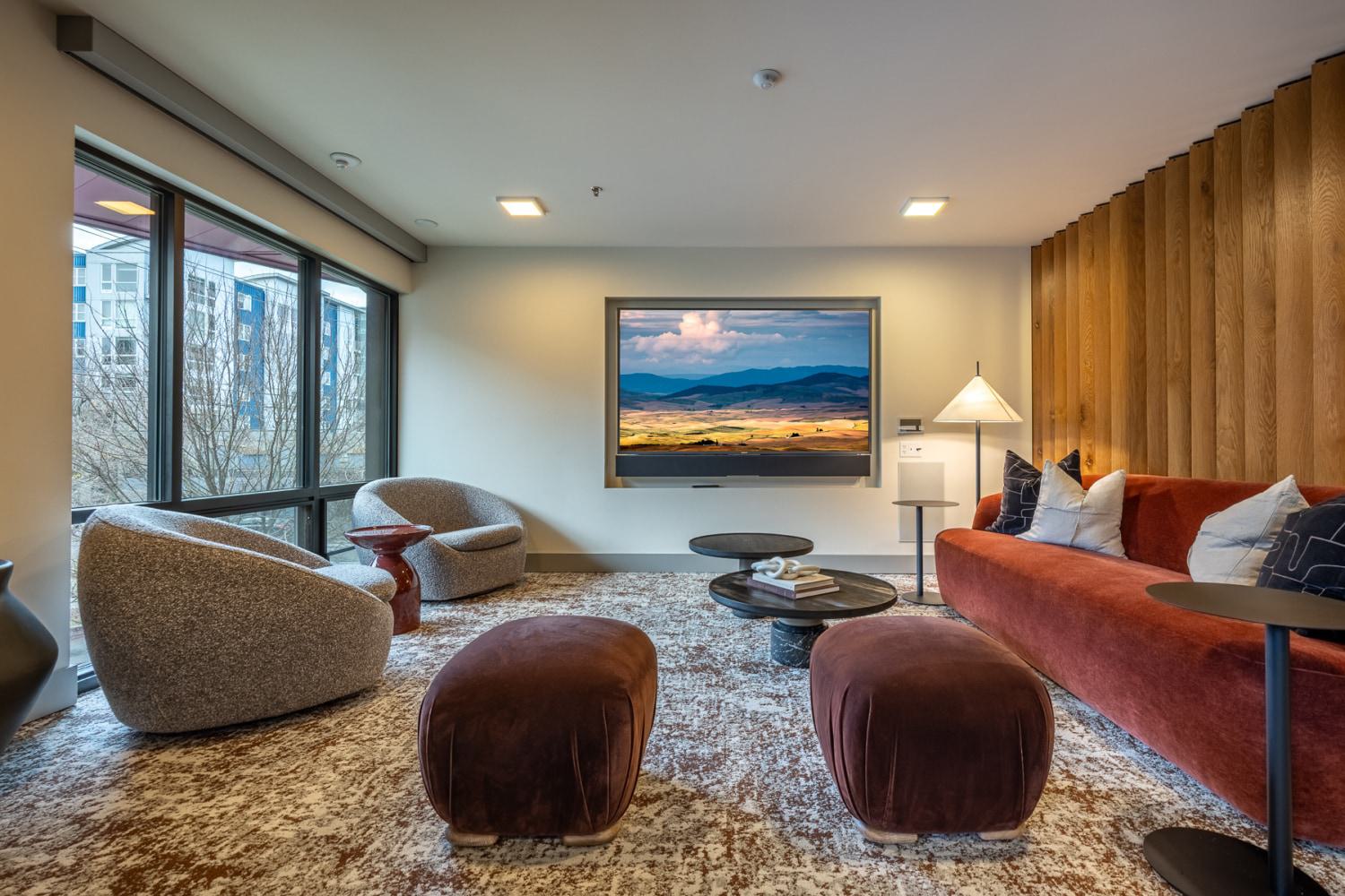 Modern indoor lounge with large windows and elevated, plush seating.