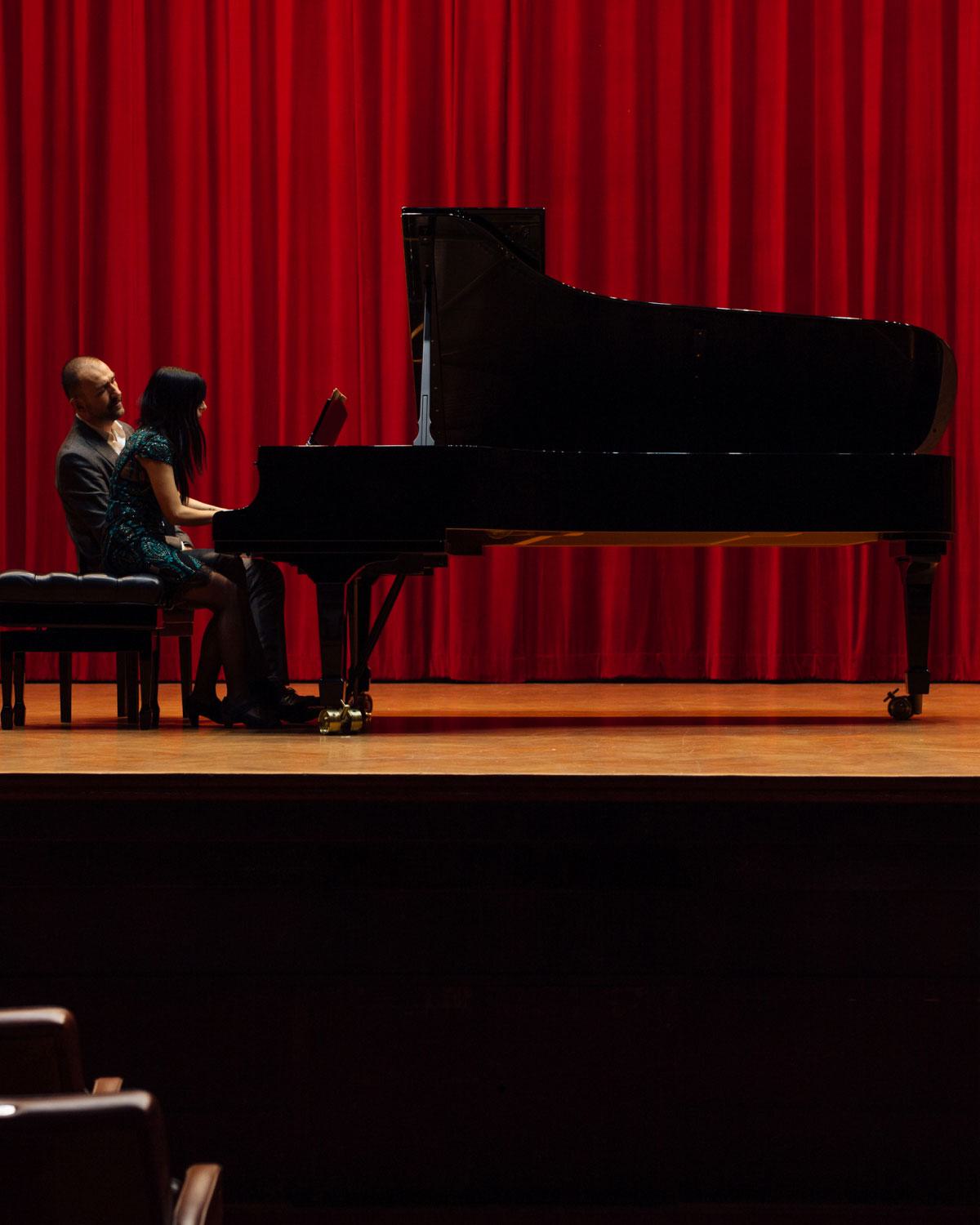 Image of two people playing piano on a stage, representing the theater district in Boston