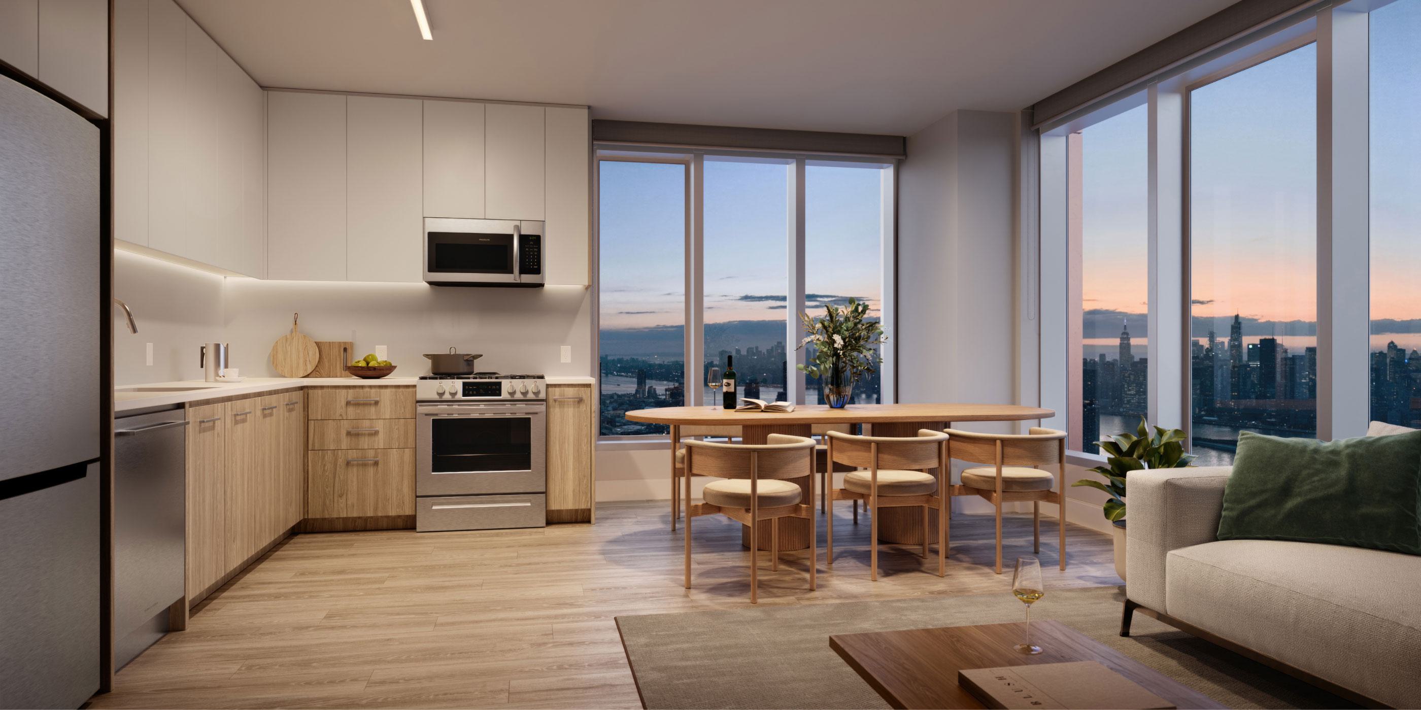 A modern open-concept kitchen and living space features sleek wood and white cabinetry, a cozy dining area, and floor-to-ceiling windows offering a stunning sunset view of the Manhattan skyline.