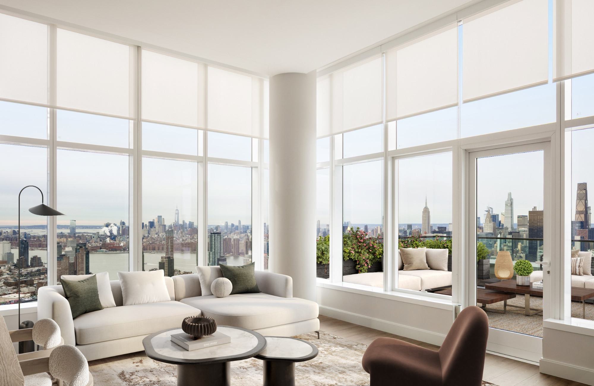 Long Island City penthouse apartment features floor-to-ceiling windows with a stunning Manhattan skyline view, a contemporary interior with a neutral-toned sectional sofa, plush blue pillows, a sculptural marble coffee table, elegant cylindrical glass pendant lights, and an outdoor terrace with modern seating and lush greenery that seamlessly extends the open, airy ambiance.