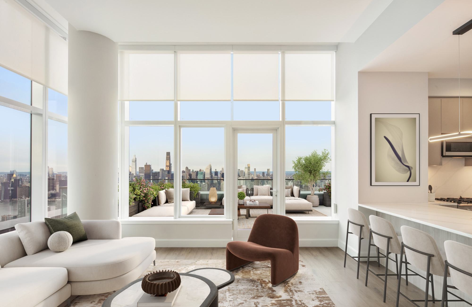 Long Island City apartment features floor-to-ceiling windows with a stunning Manhattan skyline view, a contemporary interior with a neutral-toned sectional sofa, plush blue pillows, a sculptural marble coffee table, elegant cylindrical glass pendant lights, and an outdoor terrace with modern seating and lush greenery that seamlessly extends the open, airy ambiance.