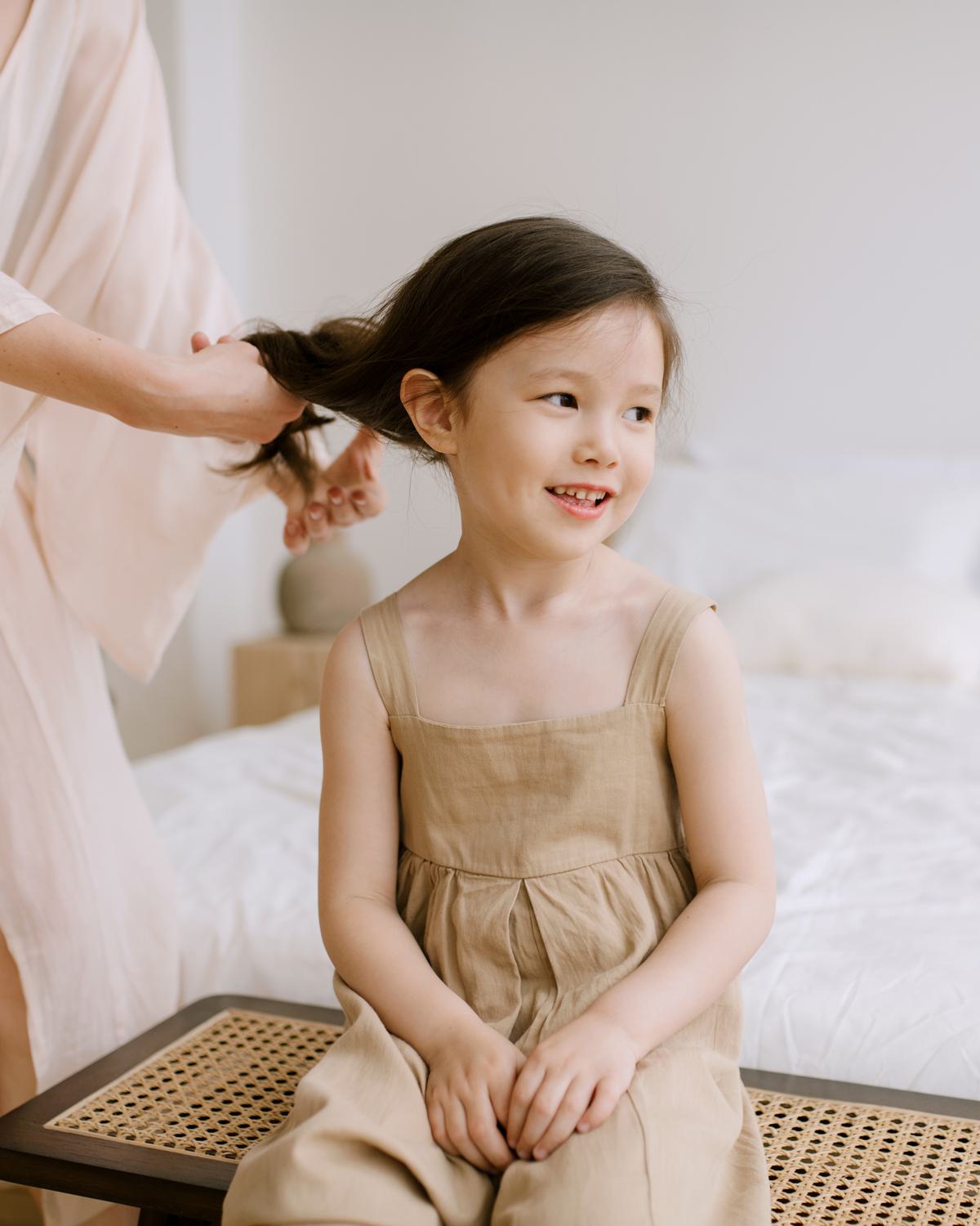 woman brushing the hair of a young girl