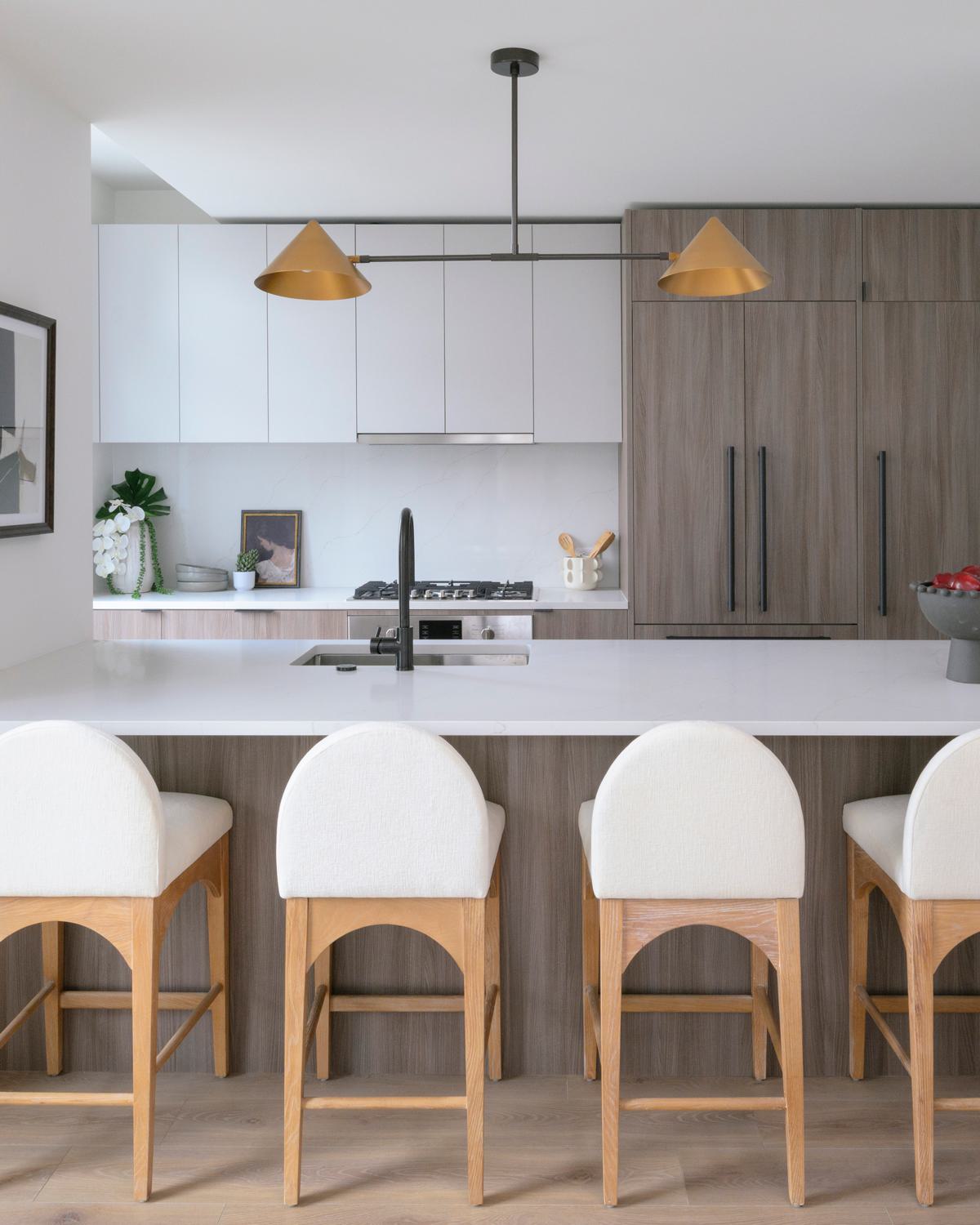 sophisticated open-concept kitchen and dining area featuring a marble island with bar seating, sleek cabinetry, warm wood accents, and floor-to-ceiling windows with city views.