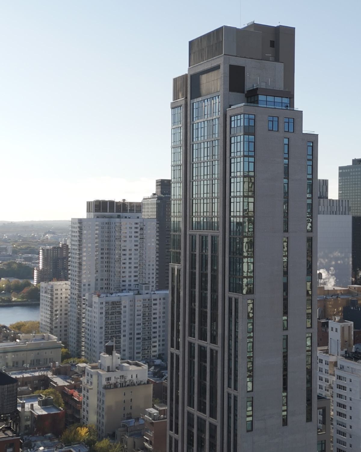 exterior of striking new Maison 78 high-rise building with modern glass and metal accents, set against a backdrop of a nyc city skyline 