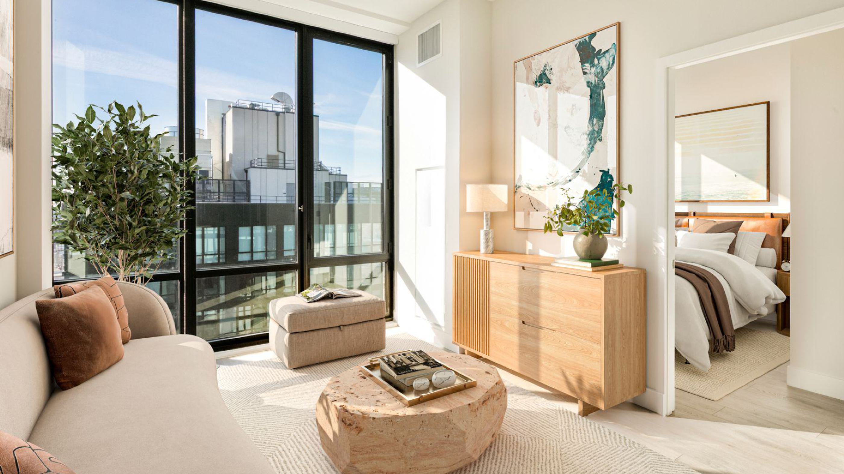 modern penthouse apartment with floor-to-ceiling windows overlooking  lush prospect park and the Manhattan skyline at sunset, showcasing a warmly lit interior