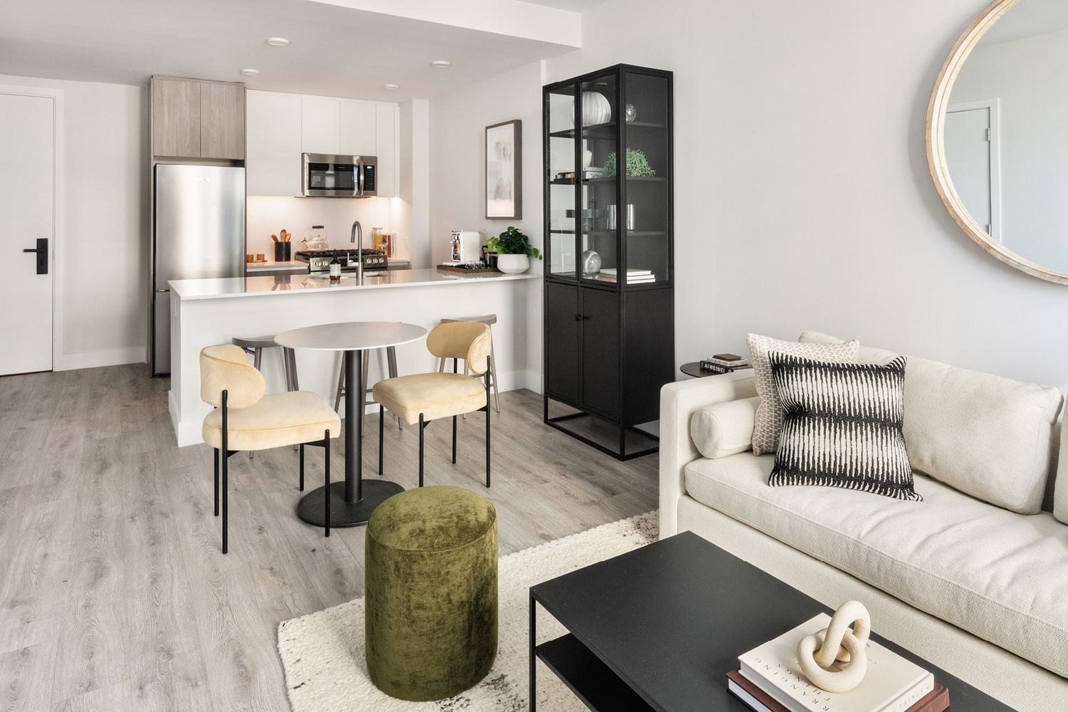 modern living space with floor-to-ceiling windows, warm neutral tones, minimalist furniture, and a breathtaking sunset view over the city skyline