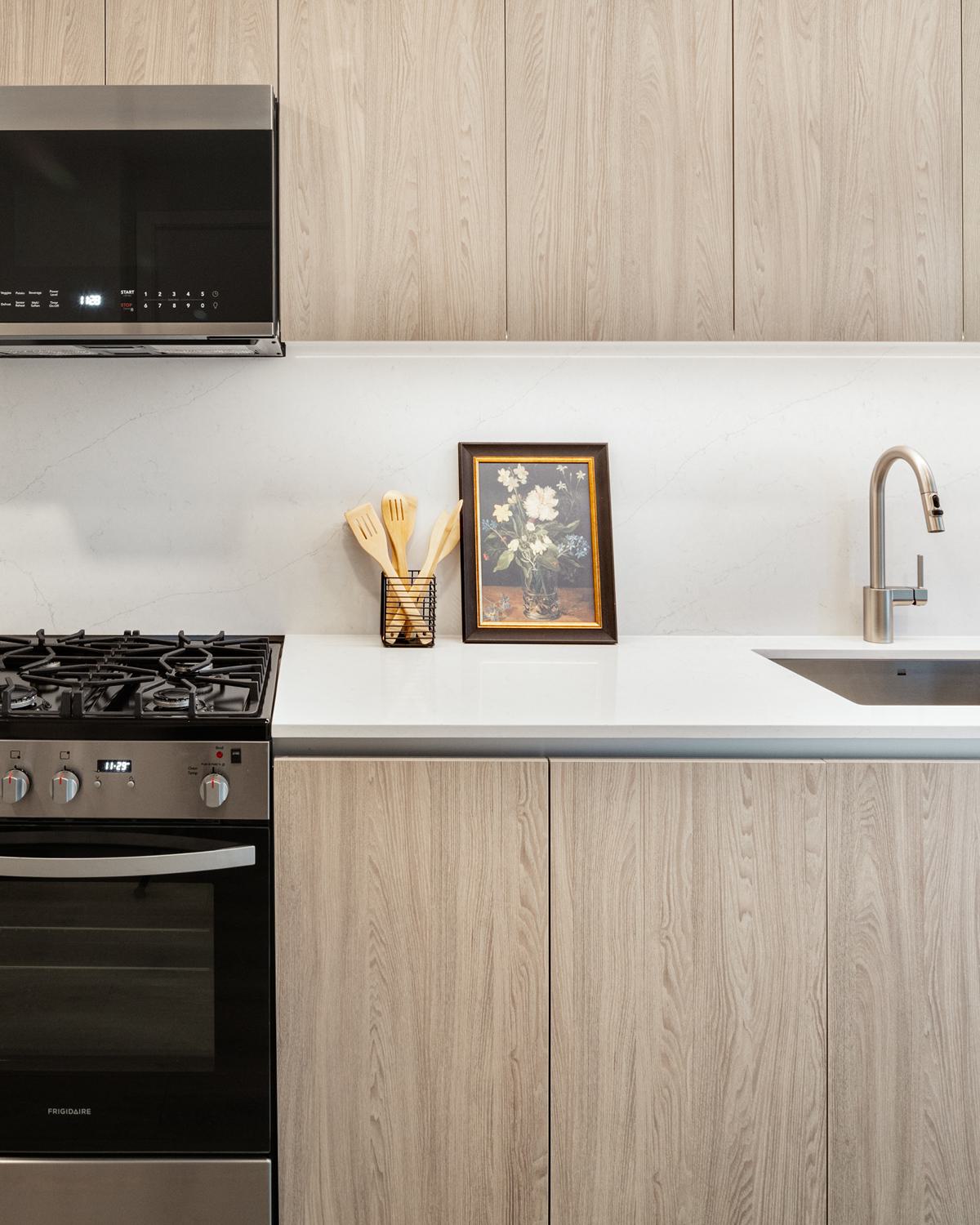 A sleek kitchen with a Olmo Volta Palette, featuring dark wood cabinetry, a marble backsplash, stainless steel appliances