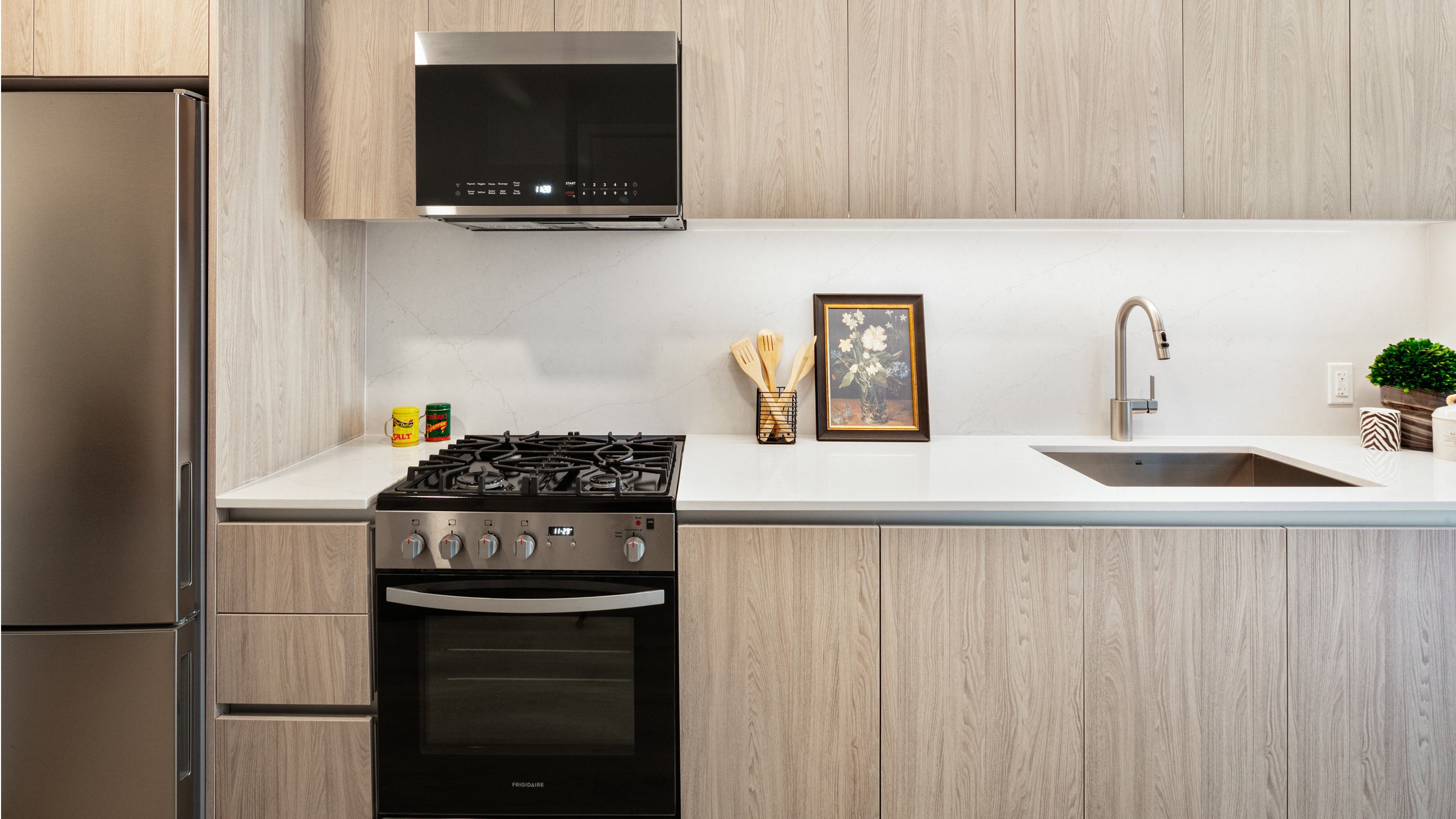 A sleek kitchen with a Olmo Volta Palette, featuring dark wood cabinetry, a marble backsplash, stainless steel appliances