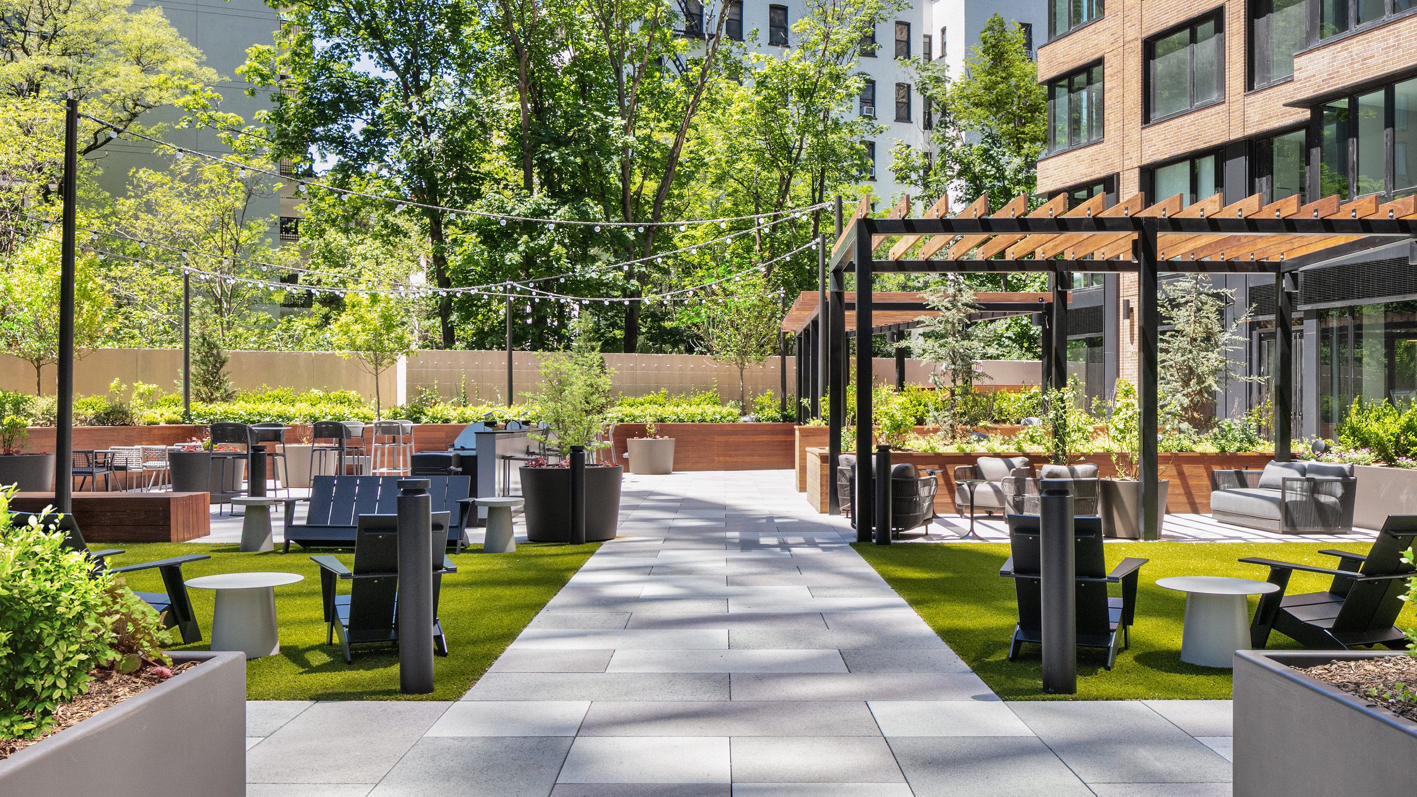 outdoor lounge featuring a central fire pit, plush seating, and a blooming cherry blossom tree, creating a cozy and elegant gathering space.