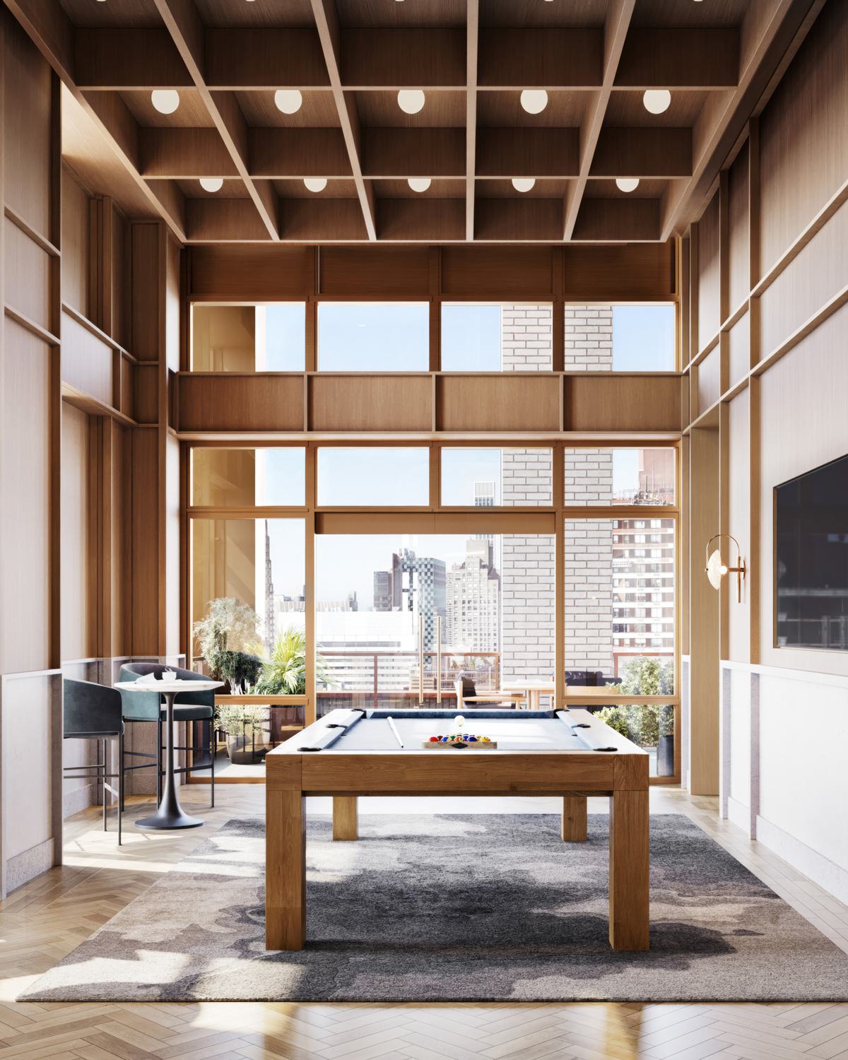 Elegant game room at Maison 78 featuring a central pool table, tall wood-paneled walls, floor-to-ceiling windows, and a coffered ceiling. A large TV is mounted on the wall, with café-style seating along the windowed perimeter and views of the Upper East Side skyline.