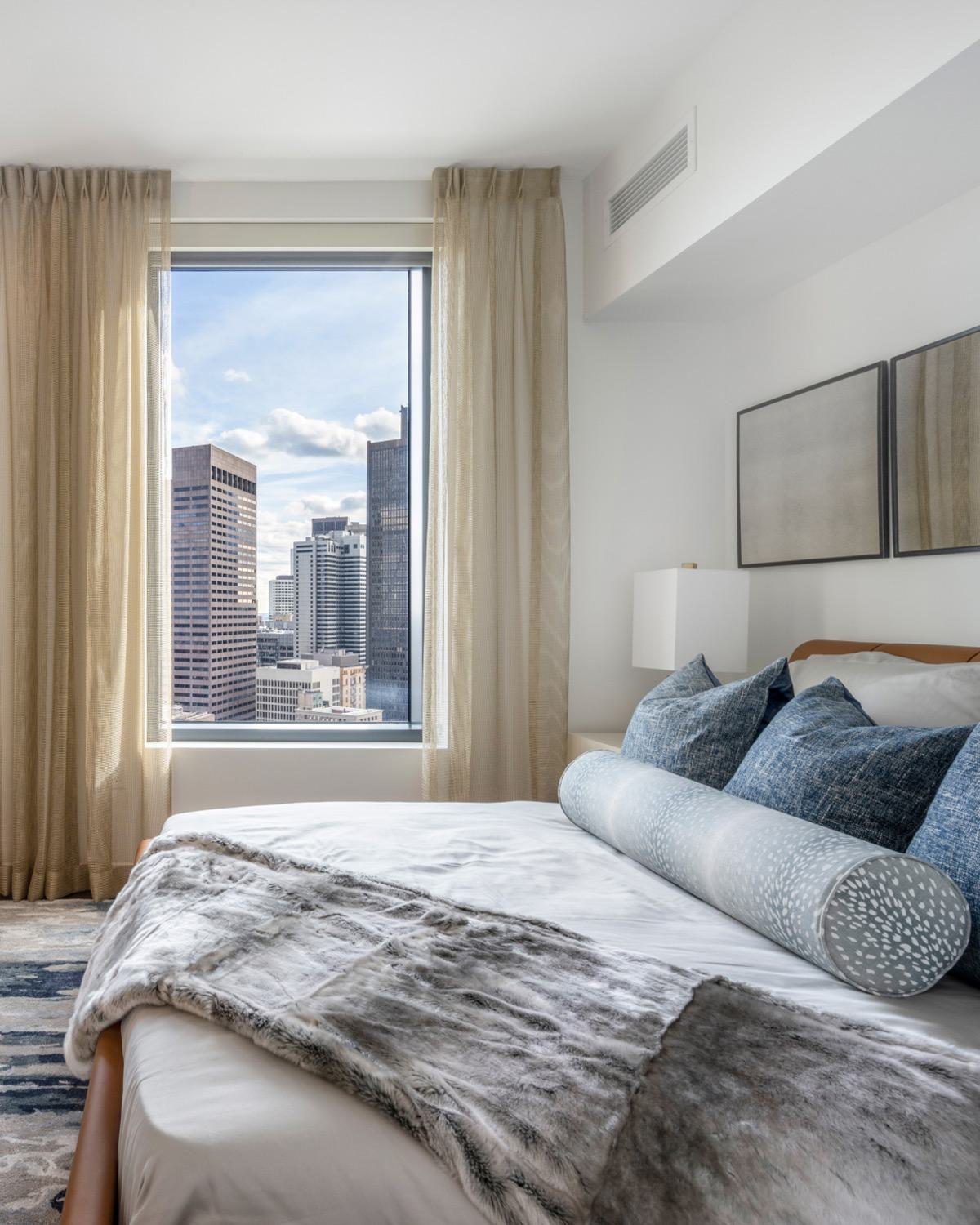 modern bedroom at the sudbury with large windows and view of downtown Boston