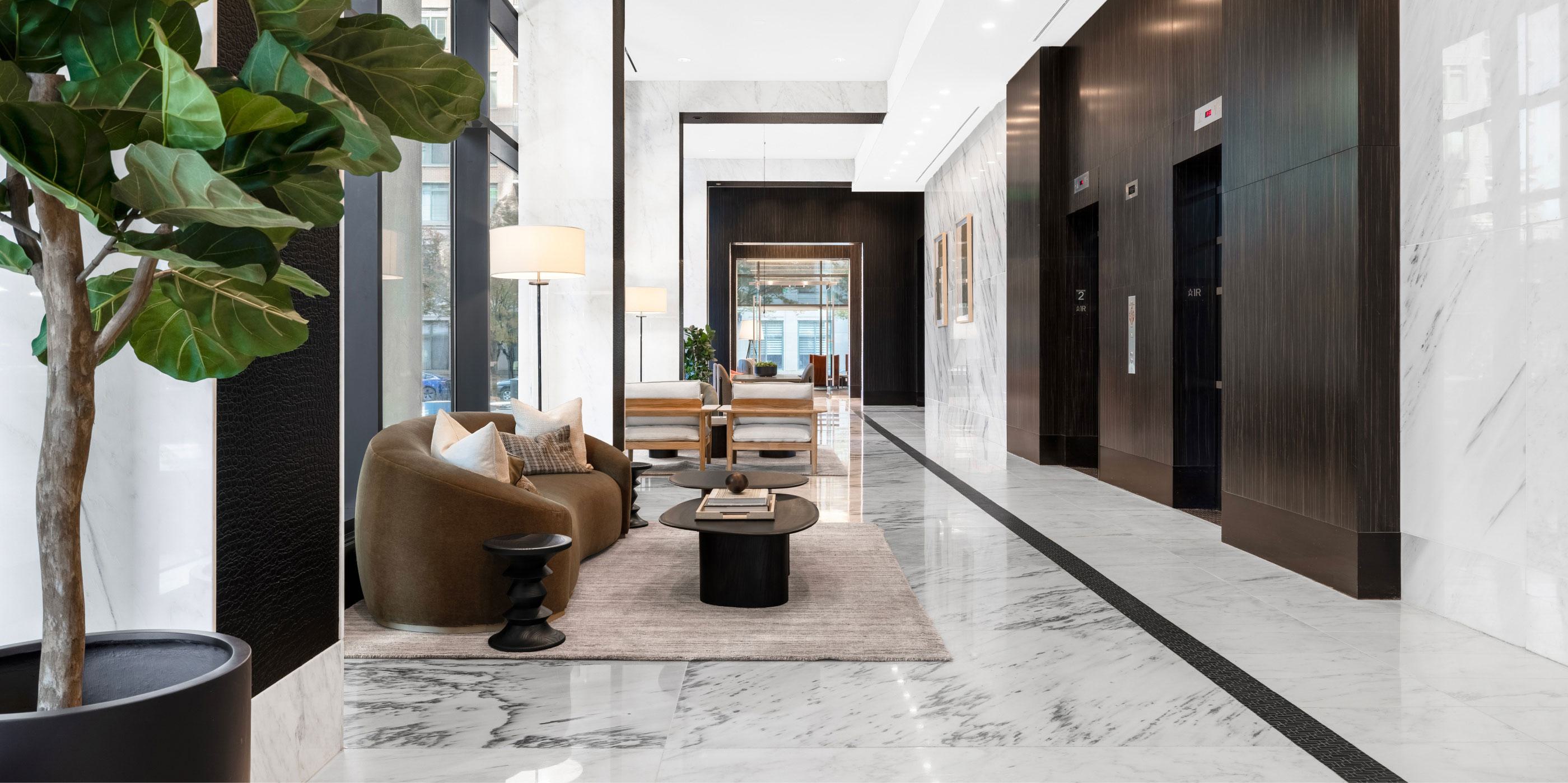 Resident lobby at Latitude Apartments in Virginia Square with sculptural lounge seating, marble floors, floor-to-ceiling windows, and a contemporary elevator hall.