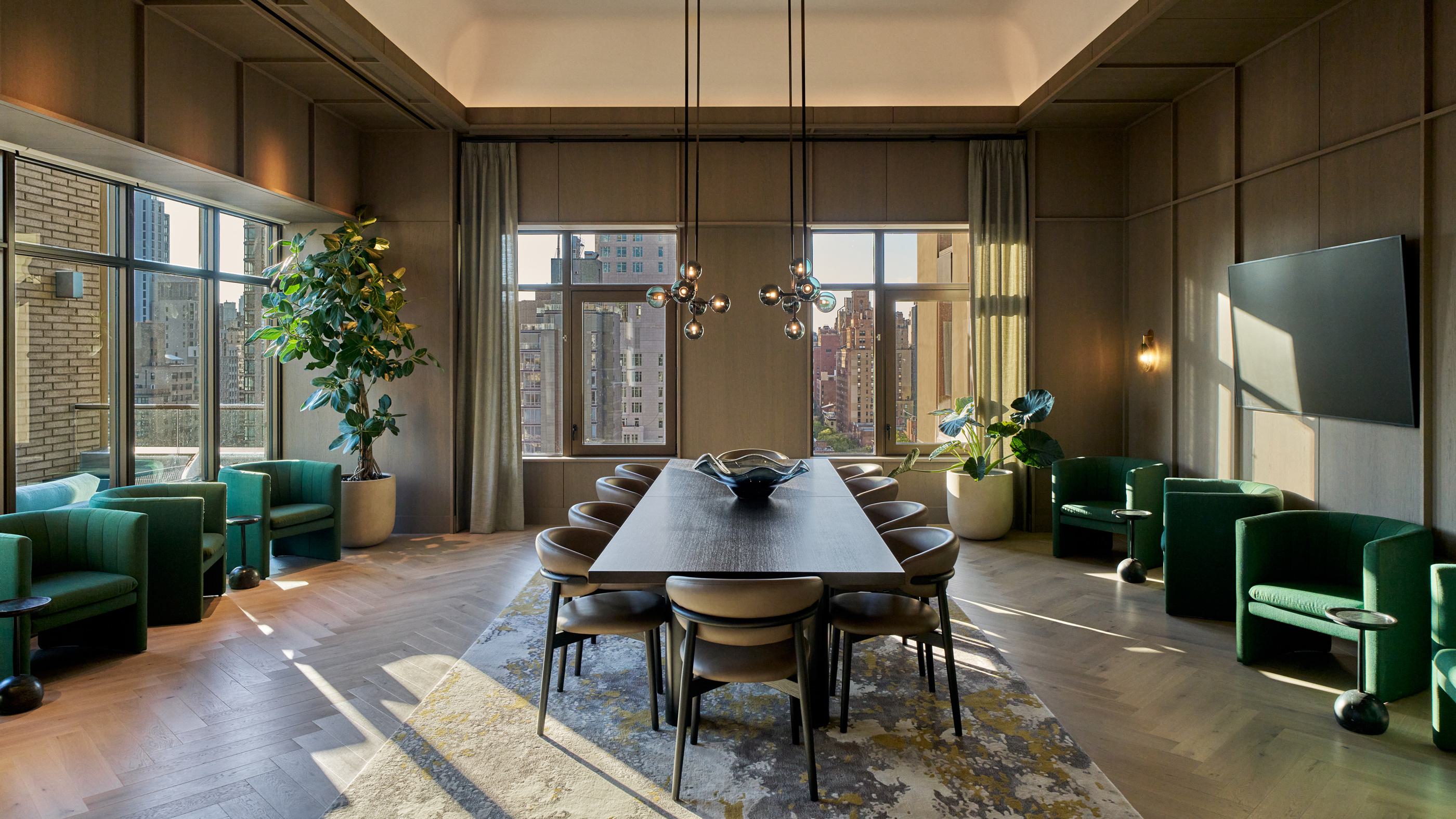 modern open-concept entertaining kitchen and dining area featuring a striking marble island, warm wood paneling, elegant chandeliers, and floor-to-ceiling windows offering a cityscape view.