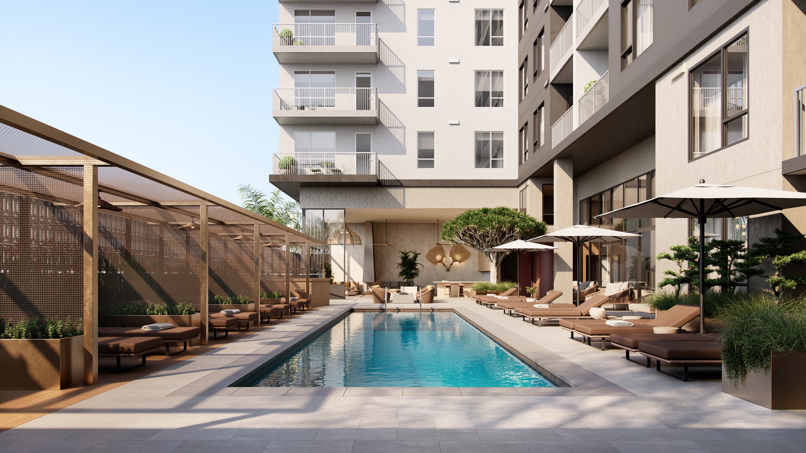 Modern outdoor pool terrace at Rowyn luxury apartment community, surrounded by cushioned lounge chairs, umbrellas, private cabanas, and lush landscaping.