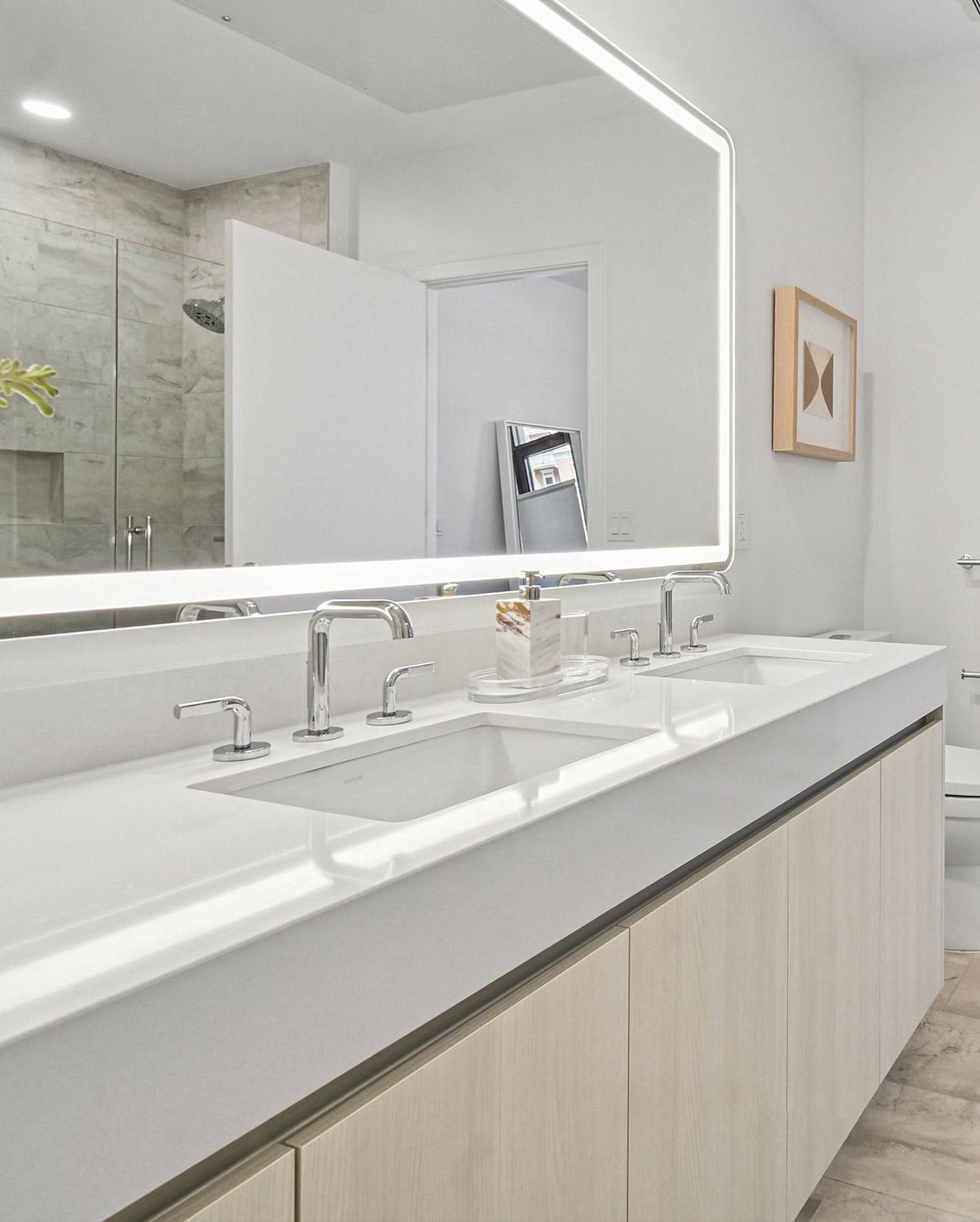 luxurious modern bathroom with marble floors, a double vanity, and a soaking tub beside floor-to-ceiling windows overlooking a city skyline.