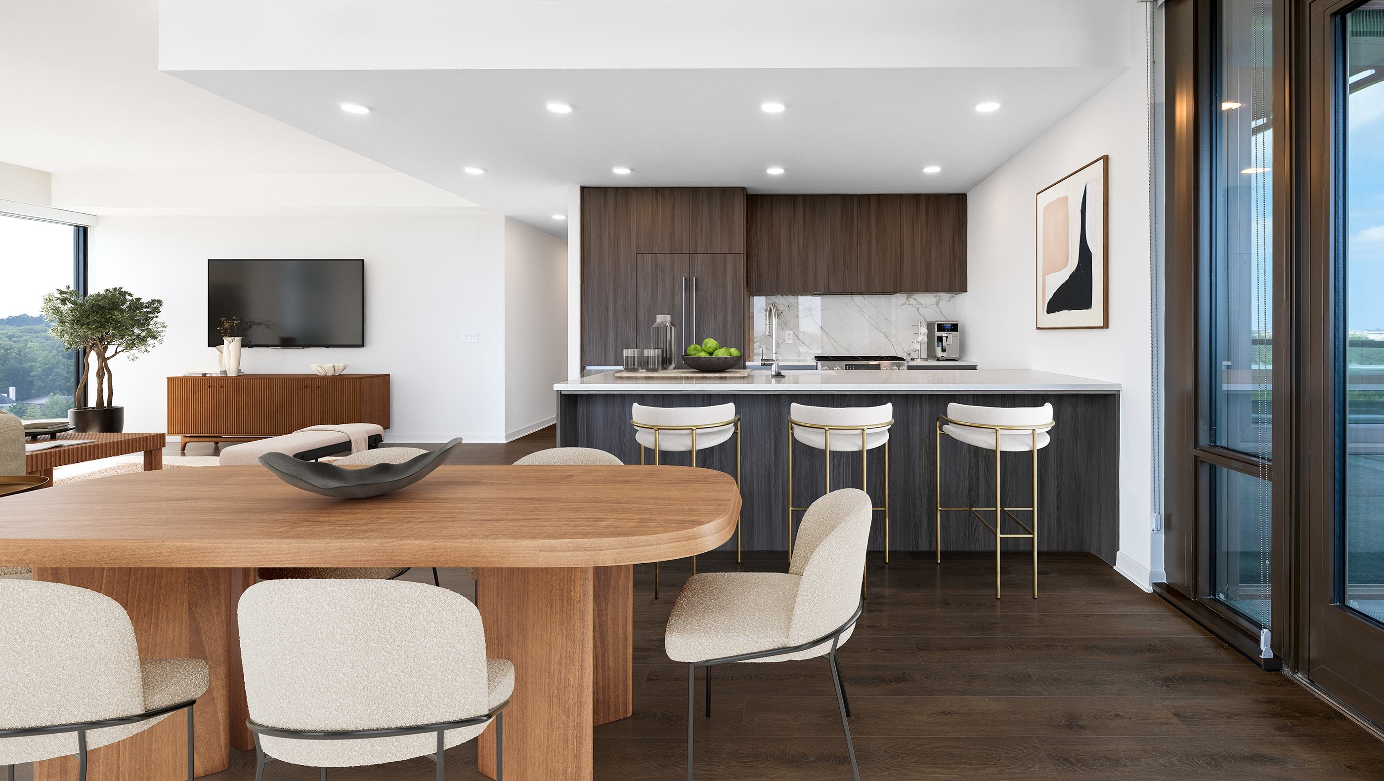An elegant open-concept living space with a modern kitchen, cozy seating area, and a wood dining table set beside floor-to-ceiling windows.