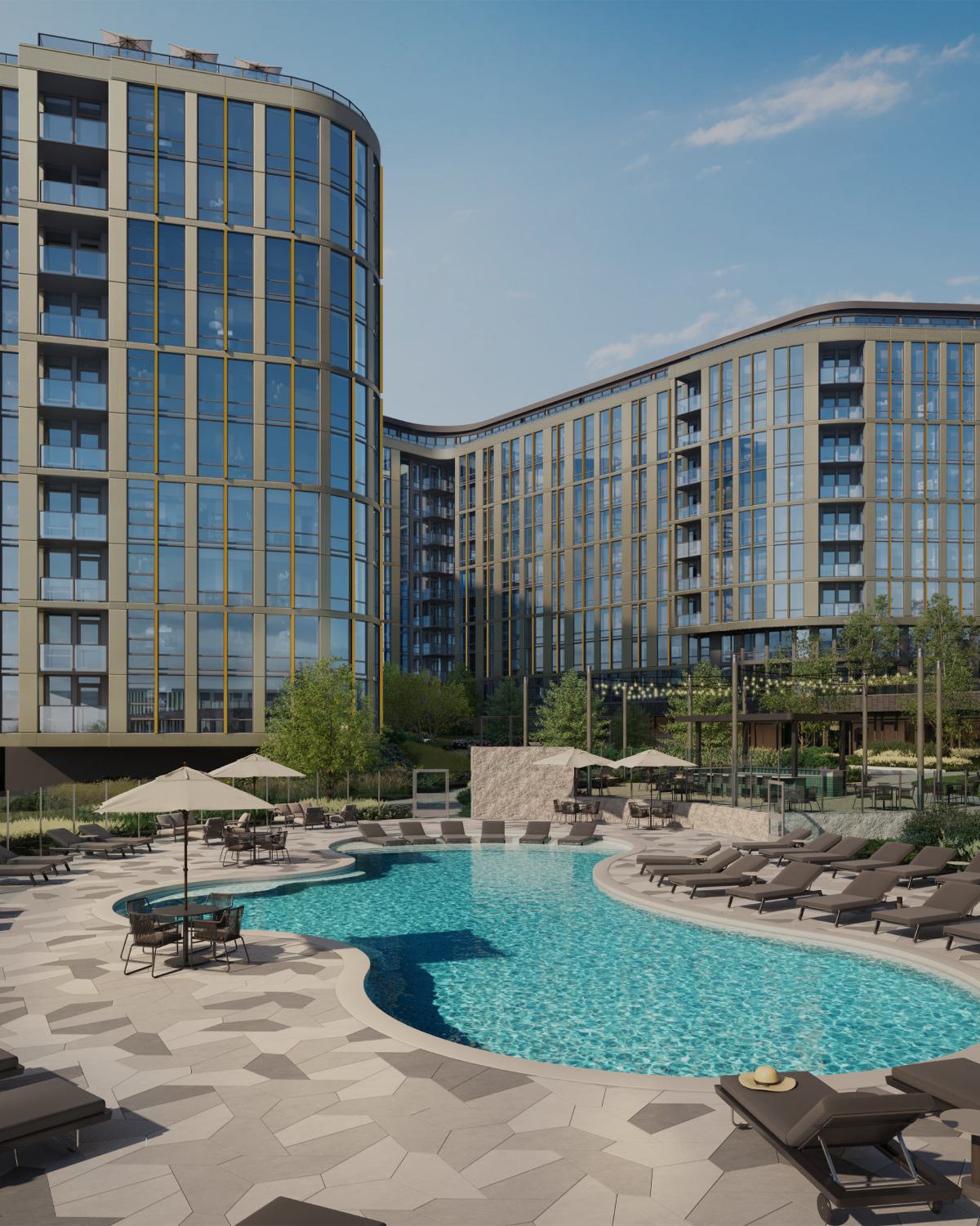 Outdoor pool deck at Zephyr, a new high-rise apartment community in Woodley Park, DC, with a curved resort-style pool, lounge seating, umbrellas, and landscaped greenery surrounded by modern glass-and-metal towers.