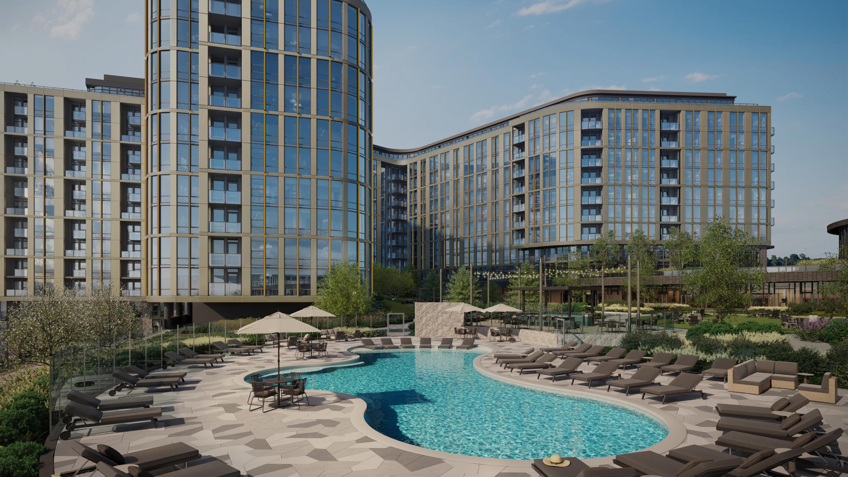 Outdoor pool deck at Zephyr, a new high-rise apartment community in Woodley Park, DC, with a curved resort-style pool, lounge seating, umbrellas, and landscaped greenery surrounded by modern glass-and-metal towers.