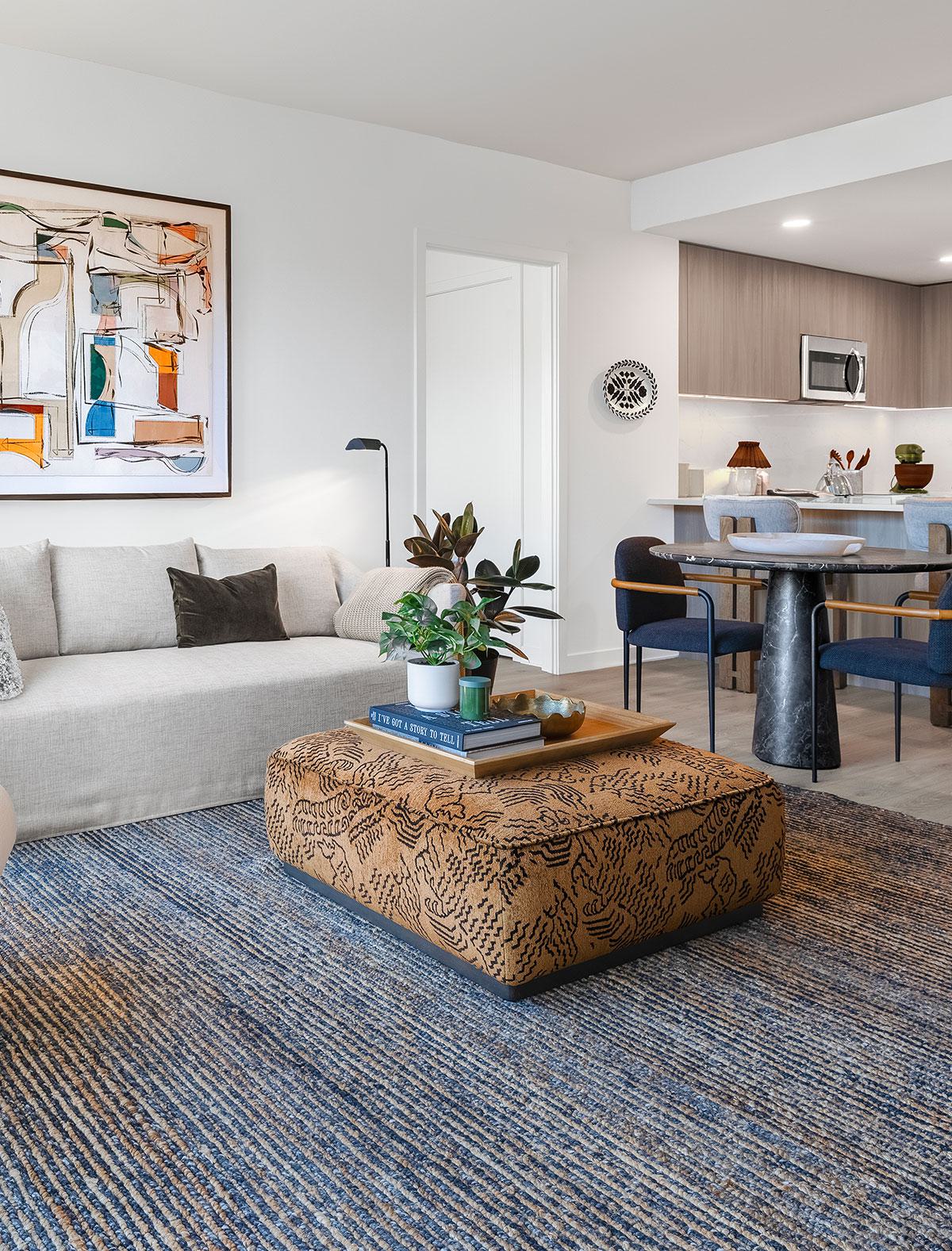 Living room at Zephyr in Woodley Park, DC, featuring a neutral-toned sofa, modern accents, and floor-to-ceiling windows.
