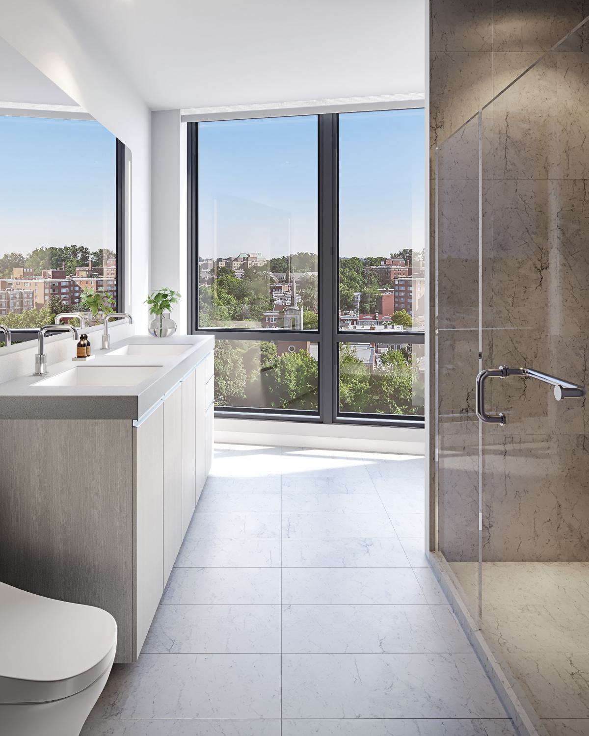 Penthouse bathroom at Zephyr in Woodley Park, DC, featuring a sleek double vanity, glass-enclosed marble shower, and expansive floor-to-ceiling windows with city and treetop views.